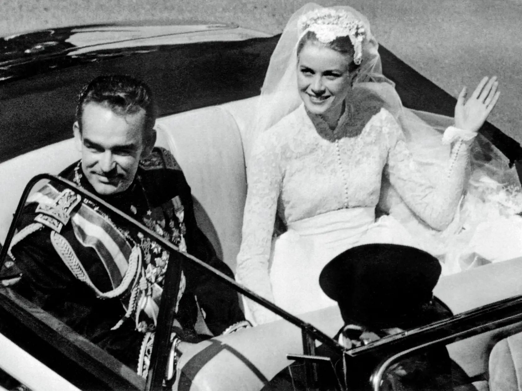 Na archívnej snímke z 19. apríla 1956 princezná Grace Kellyová máva zástupom ľudí počas jazdy v otvorenom aute po sobáši s s princom Rainerom III , ktorá sa konala v katedrále v Monaku.