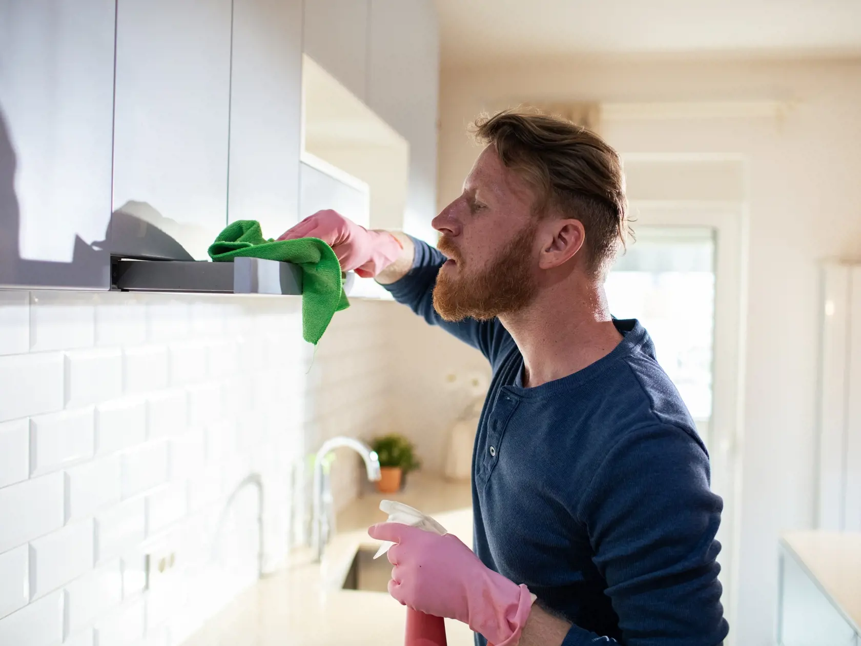 Bearded Man Cleaning the Kitchen Cabinets