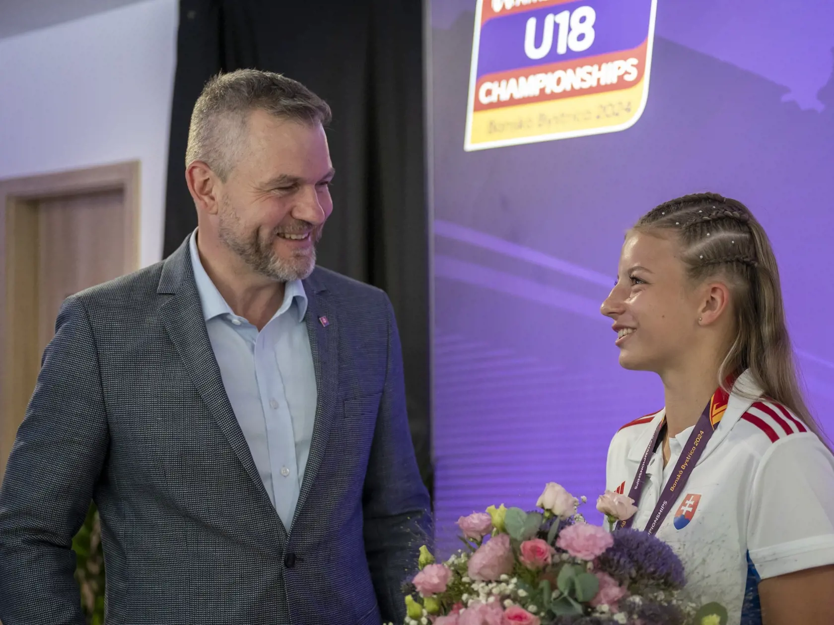 Na snímke zľava prezident Slovenskej republiky Peter Pellegrini prišiel zagratulovať zlatej medailistke v behu na 100 metrov cez prekážky Laure Frličkovej počas Majstrovstiev Európy do 18 rokov v Banskej Bystrici 20. júla 2024.