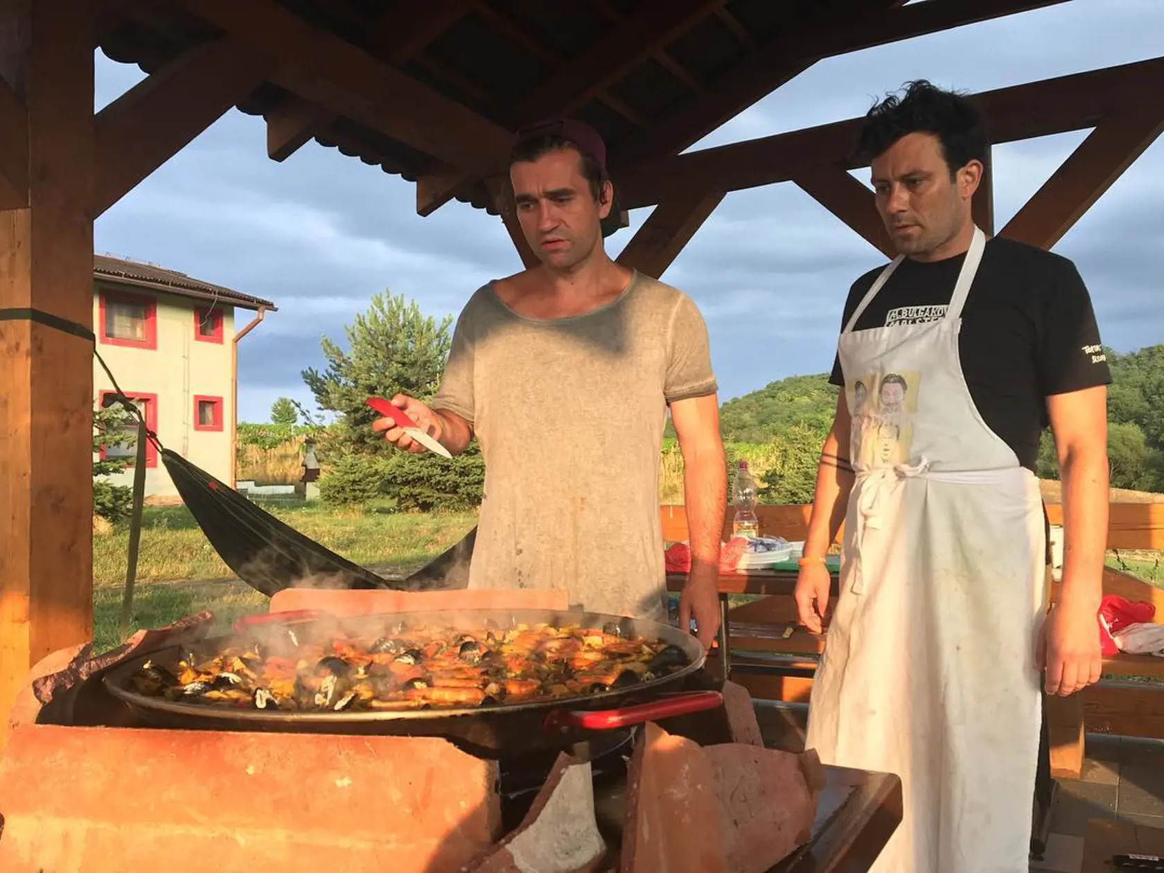 Majstri kuchári nad veľkou paellou.