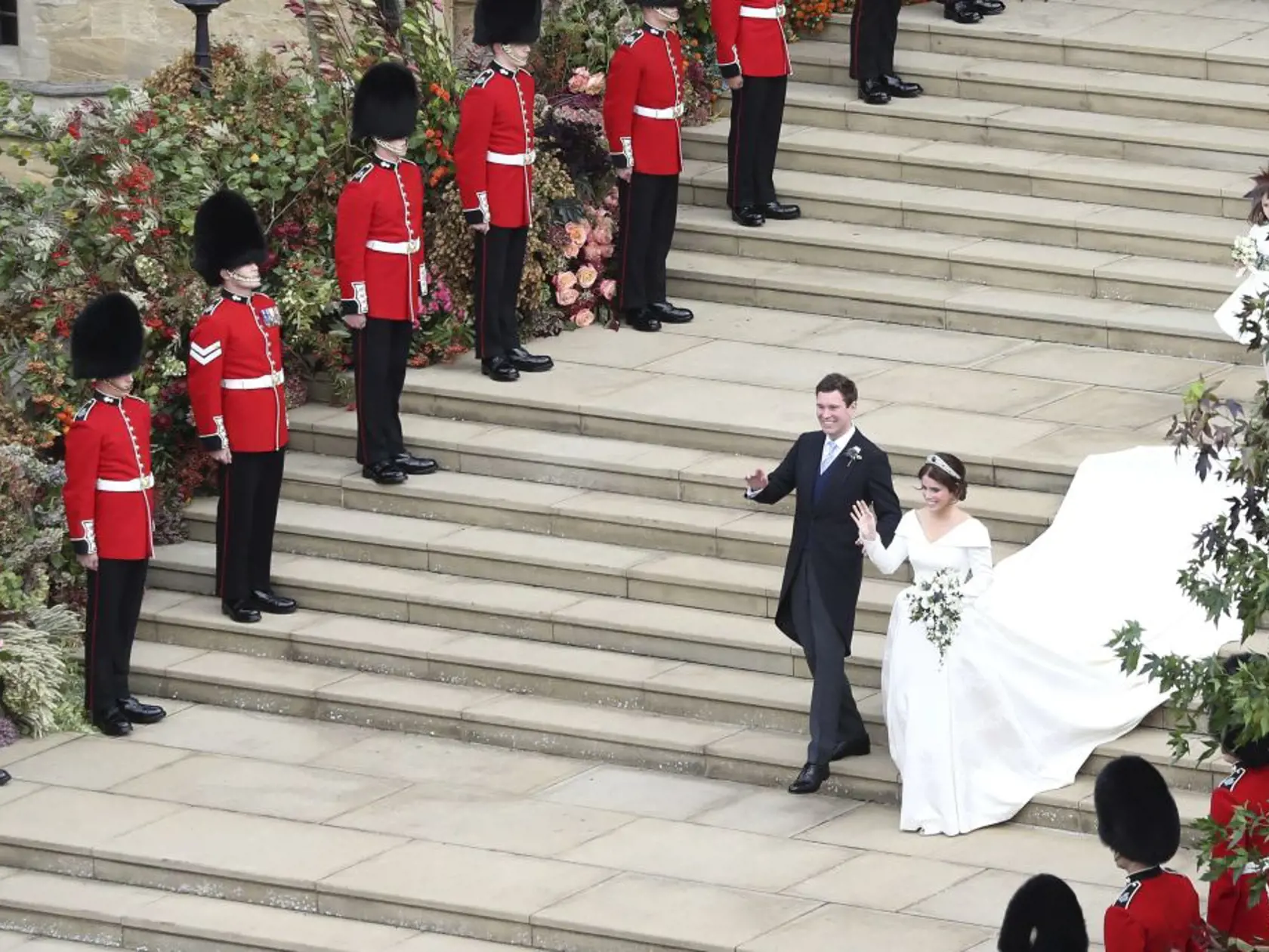 Princess Eugenie and her new husband Jack Brooksbank walk down the West Steps after their wedding ceremony as they leave St George's Chapel, Windsor Castle, near London, England, Friday Oct. 12, 2018. (Andrew Matthews, Pool via AP)