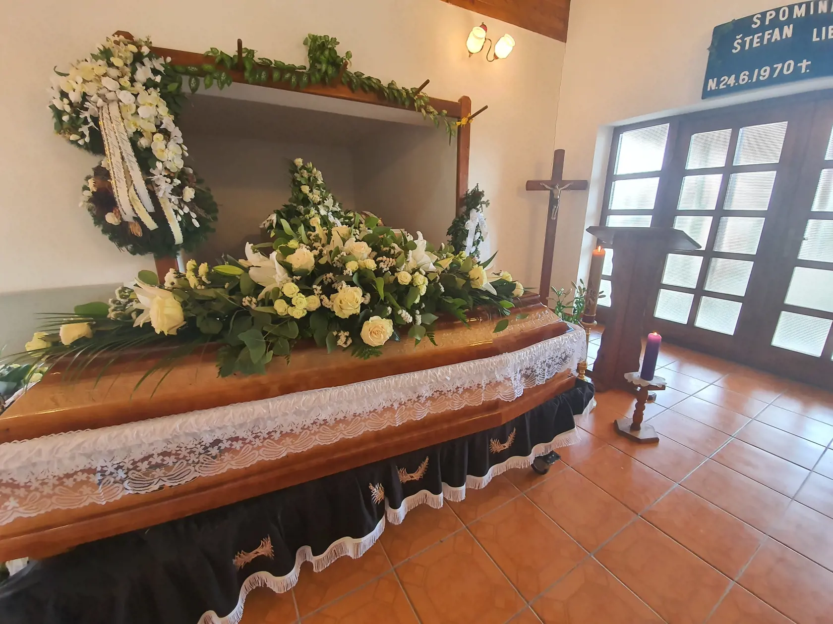 Na truhle so svetlého dreva bol položený veniec od najbližšej rodiny.