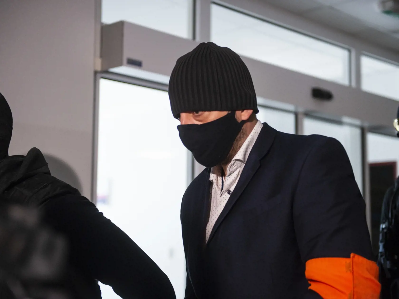 Na snímke Peter G., ktorý bol zadržaný v decembri 2020 počas akcie Judáš v sprievode Zväzu väzenskej a justičnej stráže (ZVJS) pred hlavným pojednávaním na Špecializovanom trestnom súde (ŠTS) v Pezinku 8. júla 2021. FOTO TASR - Jakub Kotian