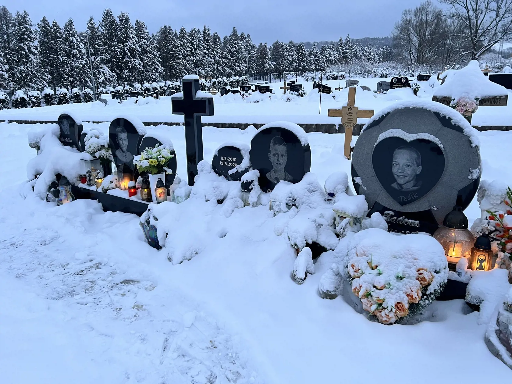 Hrobčeky štyroch malých futbalistov sú stále krásne udržiavané. Ani návaly snehu nezabránili ich príbuzných zapáliť im tam sviečku.