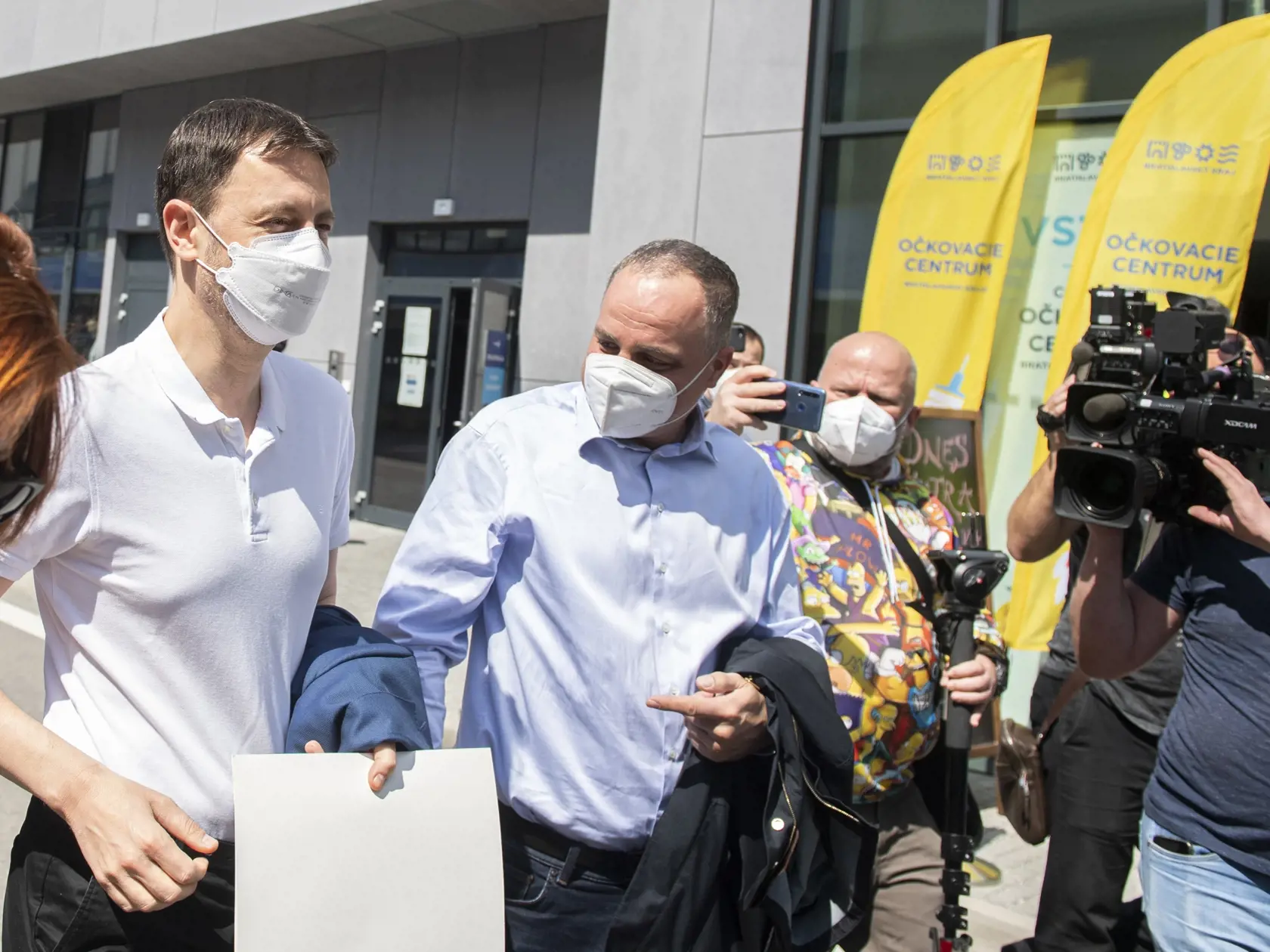 Predseda vlády SR Eduard Heger (vľavo) prichádza v sprievode predsedu Bratislavského samosprávneho kraja (BSK) Juraja Drobu na očkovanie prvou dávkou vakcíny proti ochoreniu Covid-19, v sobotu 1. mája 2021 v Bratislave.