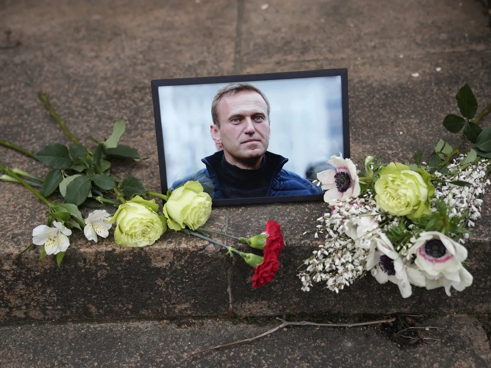 WA 29 Paríž - Na snímke ľudia položili kvety vedľa portrétu ruského opozičného lídra Alexeja Navaľného pred ruským veľvyslanectvom v Paríži v piatok 16. februára 2024. Navaľnyj zomrel vo väzení. O úmrtí neochvejného kritika ruského prezidenta Vladimira Putina v trestaneckej kolónii za polárnym kruhom informovala v piatok ruská väzenská služba. Po vychádzke mu údajne prišlo nevoľno a stratil vedomie. Väzenským zdravotníkom ani privolanej záchrannej službe sa ho už vraj nepodarilo oživiť. Príčina 
