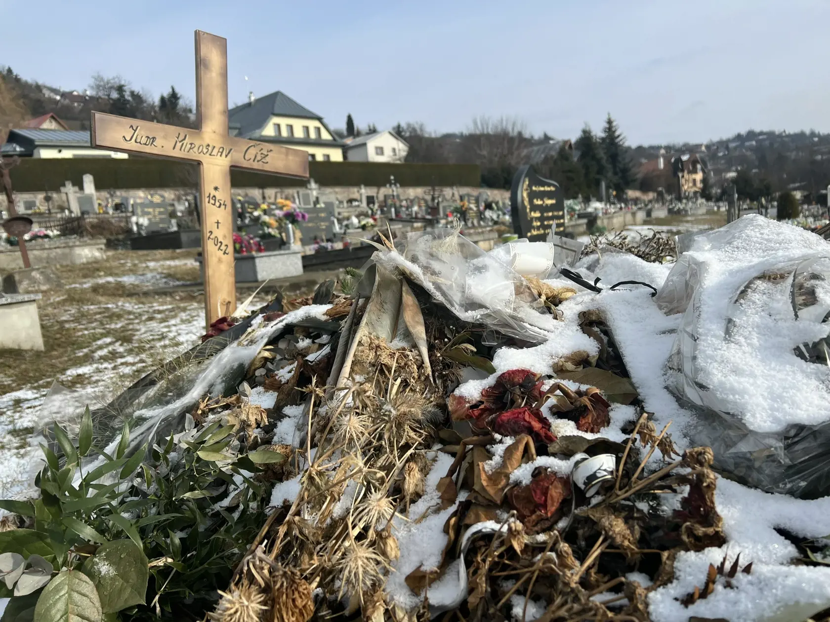 Namiesto pomníka tu dočasne stojí len jednoduchý drevený kríž a hrob pôsobí ako keby sa oň nik nestaral - ležia na ňom staré kvety ešte od pohrebu.