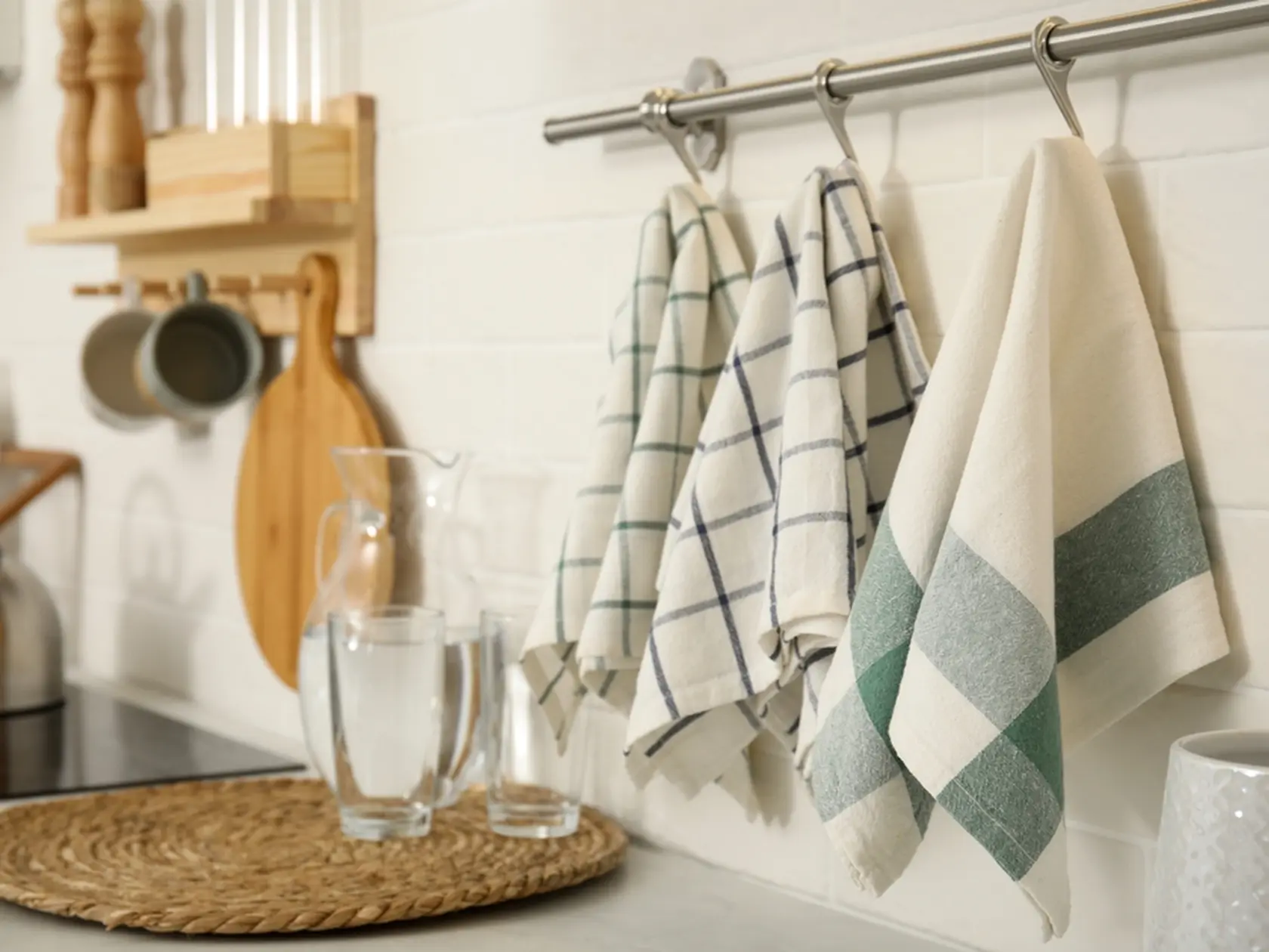 Different clean towels hanging on rack in kitchen