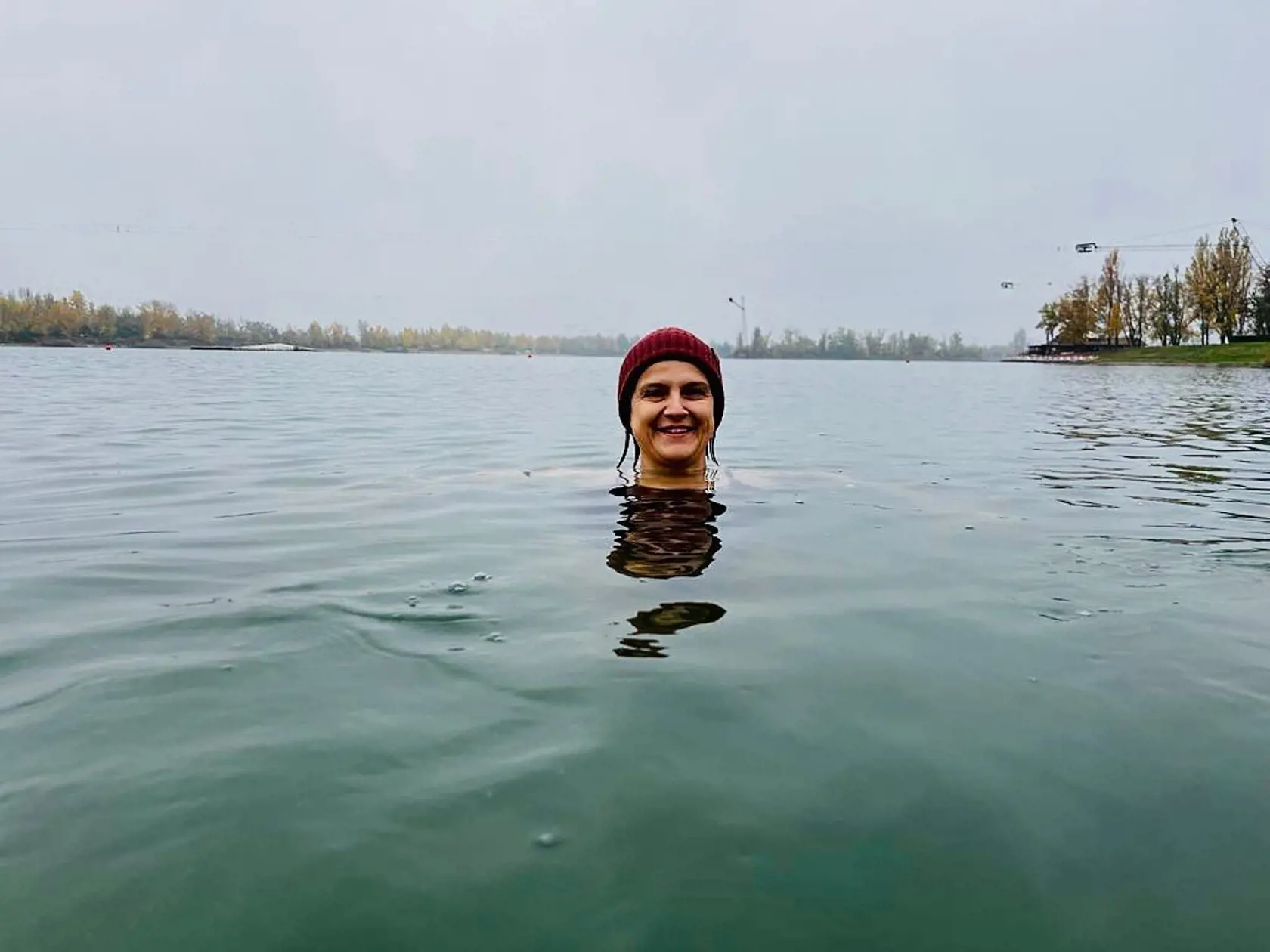 Mária Kolíková: Trošku sa schladilo, voda od 10-12 stupňov. Menila sa podľa toho, kto to zisťoval. Vo vode 15 minút. Už toľko neplávem na začiatku, ale až neskôr. Niektorí z vás mi tak radili a aj ostrieľaní otužilci mi potvrdili, že najprv treba v kľude vydržať. Ťažké je to 🙂. Zaujímavý je ten pokoj, kľud, ktorý príde do času. Kým telo nezistí, že sa treba triasť 🥶. A áno, mám čiapku.