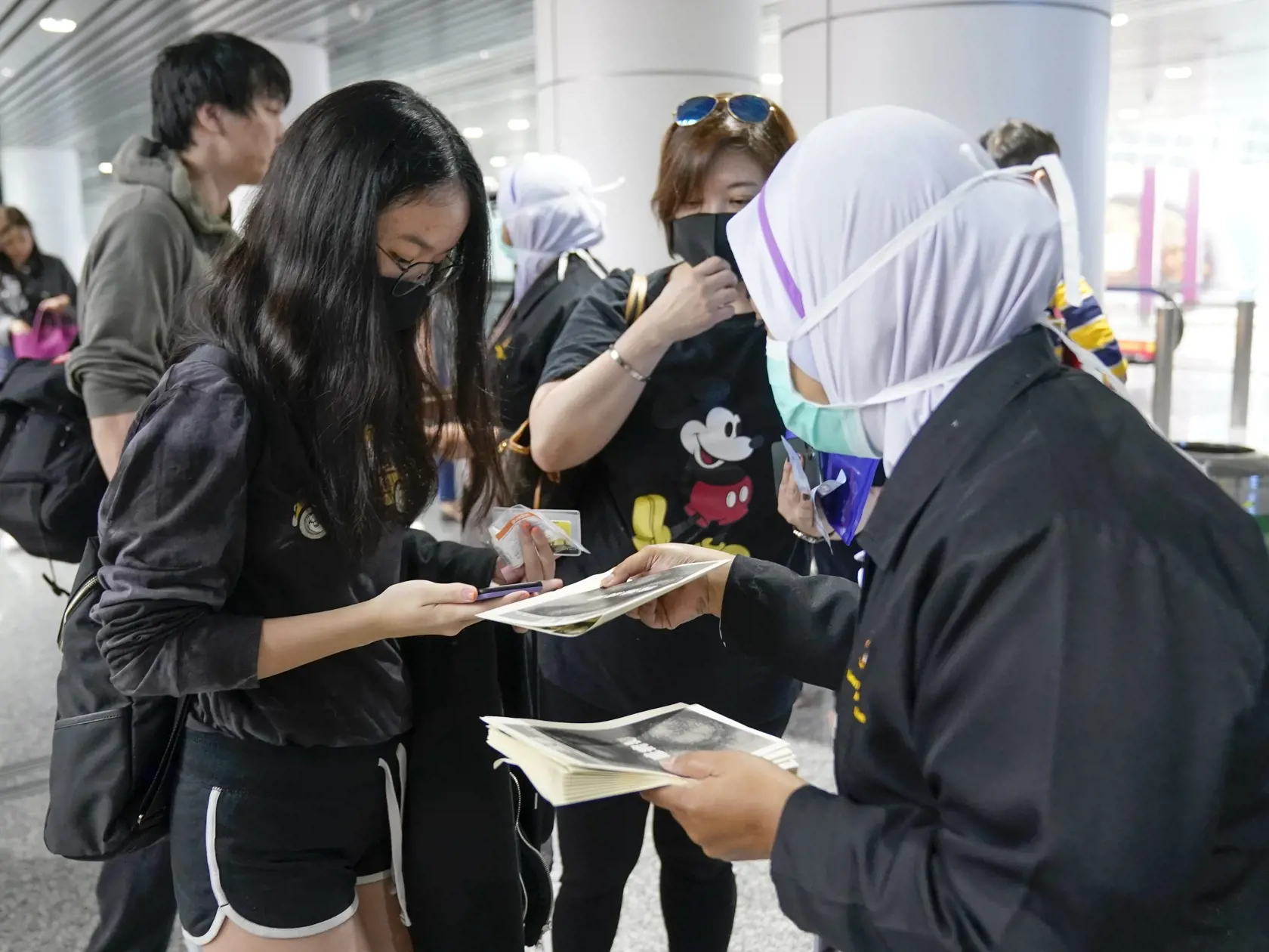WA 17 Sepang - Zdravotný personál rozdáva turistom letáky s informáciami o koronovíruse na medzinárodnom letisku v malajzijskom Sepangu utorok 21. januára 2020. Na šesť stúpol v utorok počet obetí nákazy spôsobenej v Číne novým vírusom podobným SARS, informovala agentúra AFP. Tento nový, doteraz neznámy vírus spôsobujúci zápal pľúc sa prenáša  z človeka na človeka. Úrady vo Wu-chane, ktorý je predpokladaným zdrojom nákazy, zakázali turistom opustiť územie tohto mesta. Mesto takisto umiestnilo in