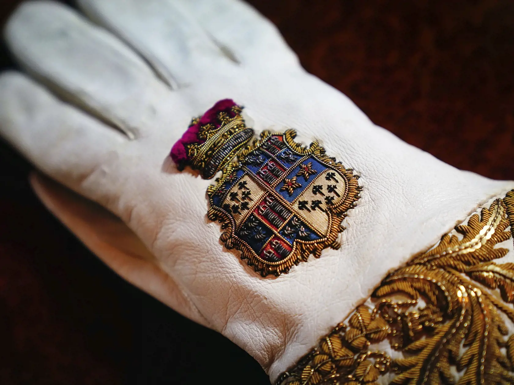 Na snímke biela kožená korunovačná rukavica s erbom je vystavená v Buckinghamskom paláci 26. apríla 2023 v Londýne. Korunovácia Charlesa III. vo Westminsterskom opátstve sa bude konať 6. mája a zúčastnia sa na nej predstavitelia mnohých krajín sveta.