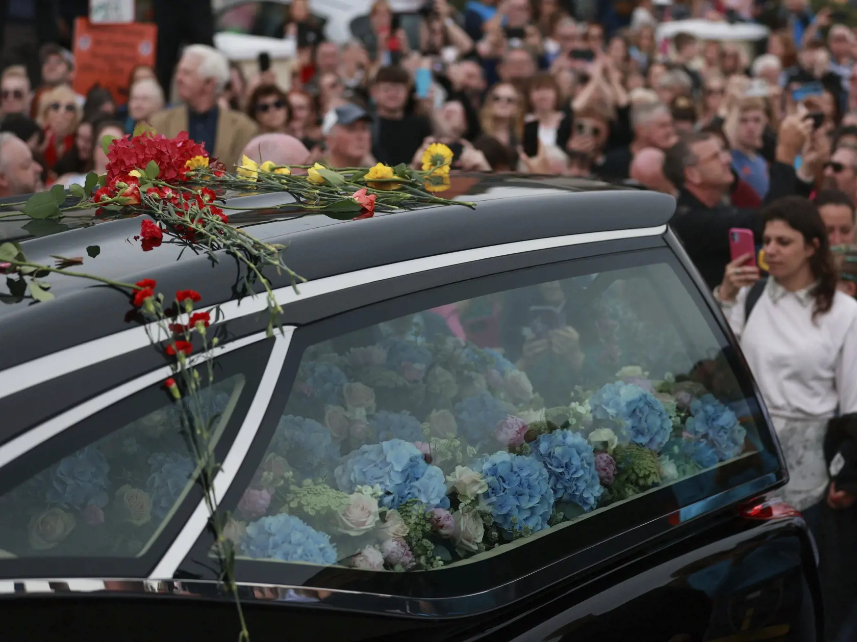 JB 39 Bray - Fanúšikovia lemujú auto s telesnými pozostatkami írskej speváčky Sinead O'Connorovej počas pohrebnej procesie cez jej rodné mesto v írskom meste Bray 8. augusta 2023. V meste Bray na východnom pobreží Írska dnes pochovajú speváčku Sinead O'Connorovú, ktorá zomrela 26. júla vo veku 56 rokov. FOTO TASR/AP

Fans of Sinead O'Connor line the street as her funeral cortege passes through her former hometown of Bray, Co Wicklow, Ireland, Tuesday, Aug. 8, 2023. Oâ€™Connorâ€™s family invited 