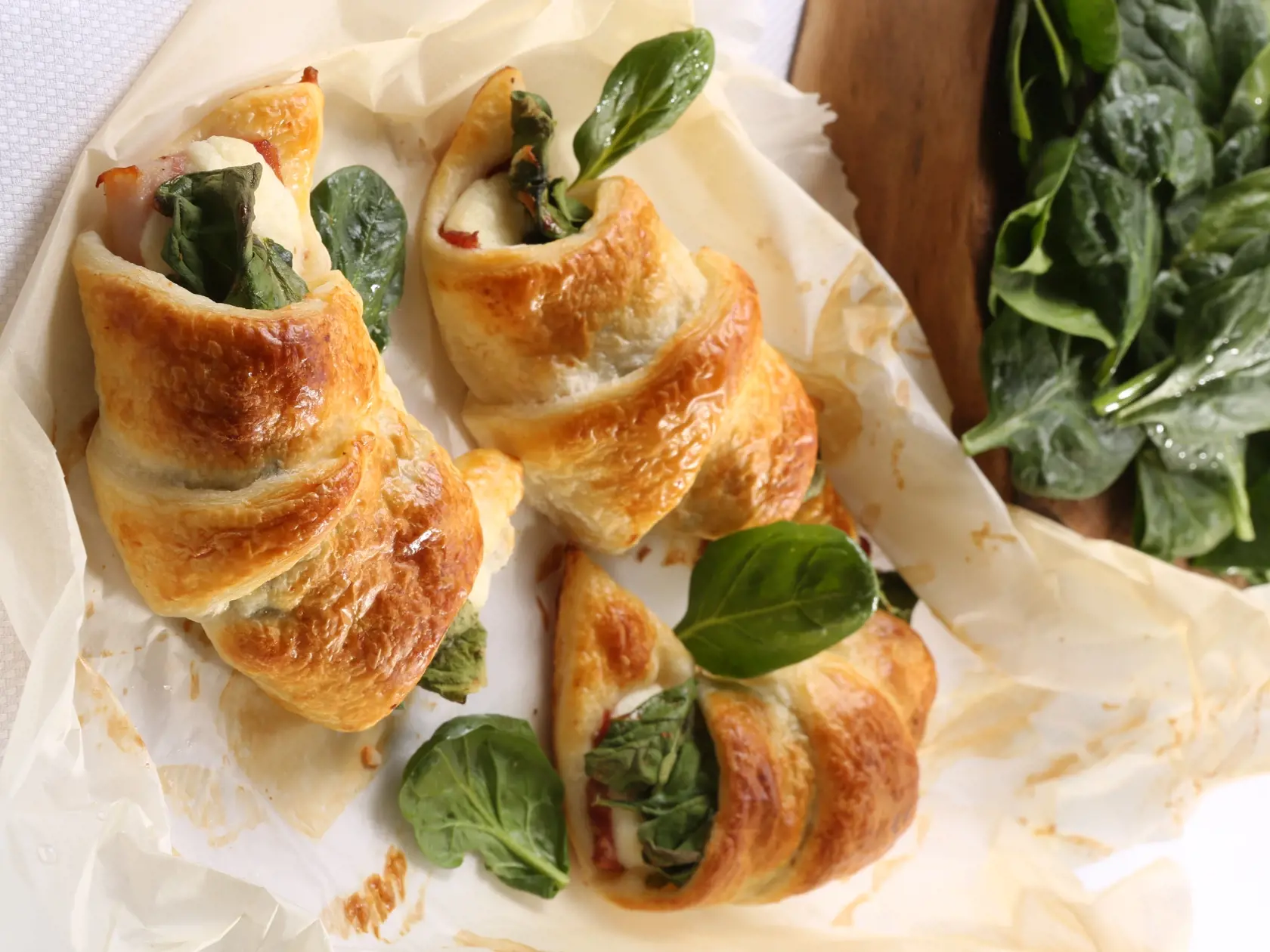 Slané jarné koláče. 

Špenátové 
croissanty 
so slaninou 
Potrebujeme: 
lístkové cesto, hrsť mladého špenátu, 
200 g údeného syra, 
200 g oravskej slaniny, 1 vajce 
Ako na to: Cesto rozvaľkáme a vykrojíme z neho trojuholníky, ktoré 
budeme rolovať na croissanty. Na ne ukladáme plátky slaniny, syra 
a špenát. Zvinieme, potrieme vajcom a pečieme do zlatista.
