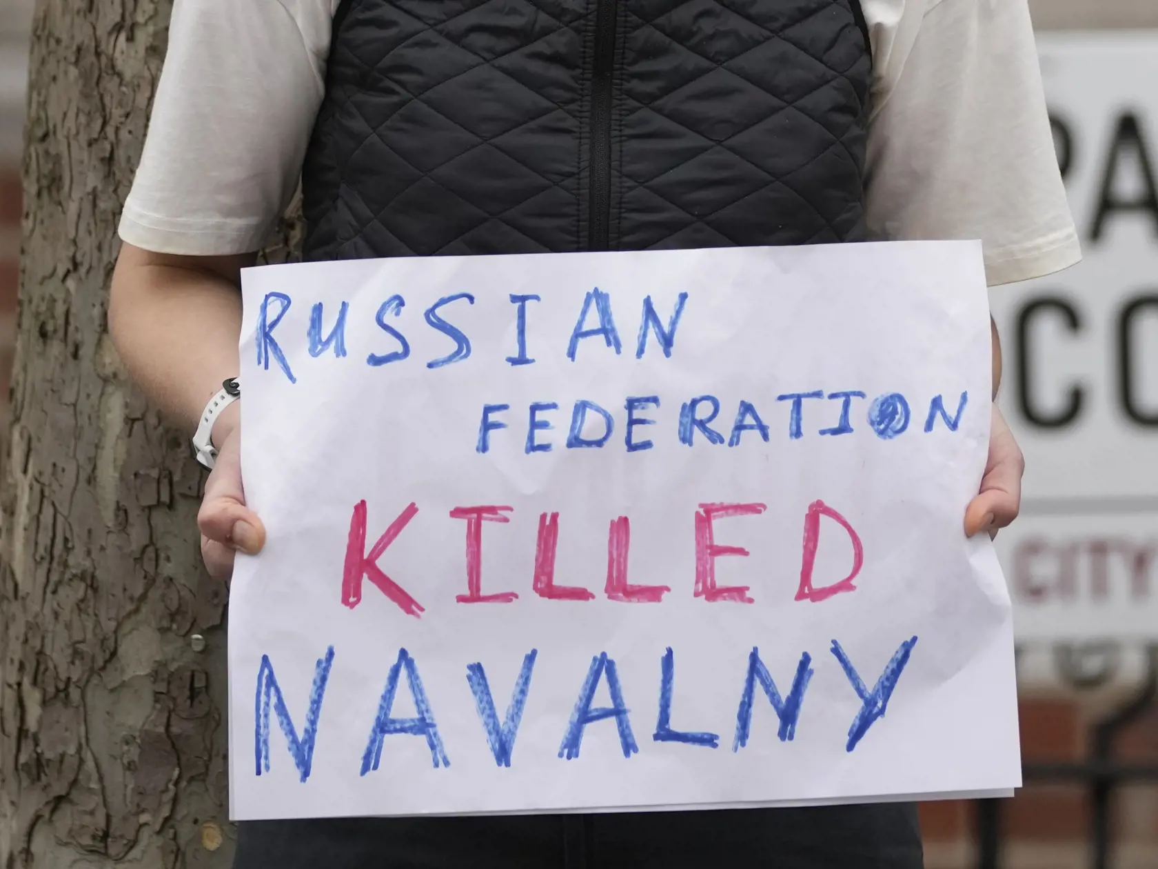Žena drží transparent s nápisom "Ruská federácia zabila Navašného "pred ruským veľvyslanectvom v Londýne v piatok 16. februára 2024.