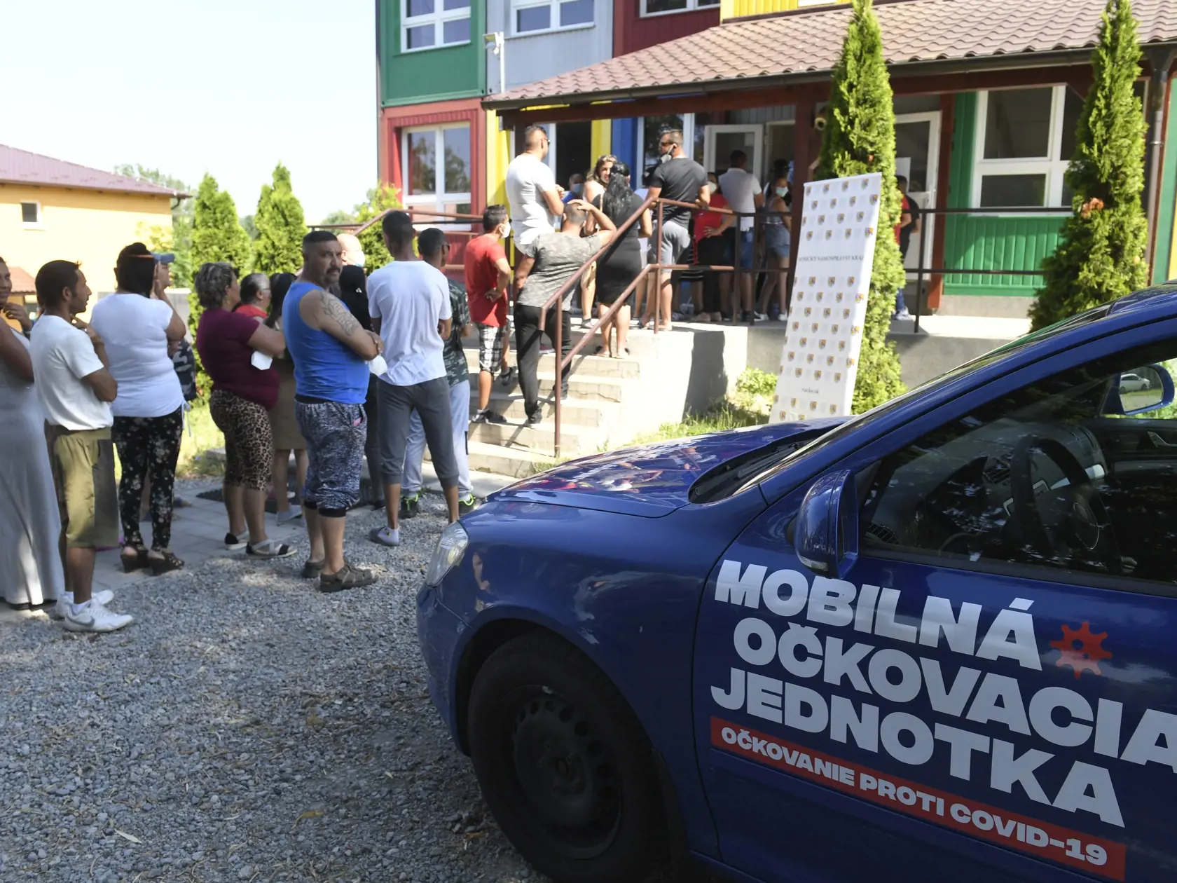 Začiatok očkovania ľudí z marginalizovaných komunít v Košickom samosprávnom kraji. Na snímke Rómovia z osady v obci Kecerovce, v okrese Košice-okolie čakajú v rade na očkovanie pred základnou školou v pondelok 28. júna 2021. FOTO TASR – František Iván