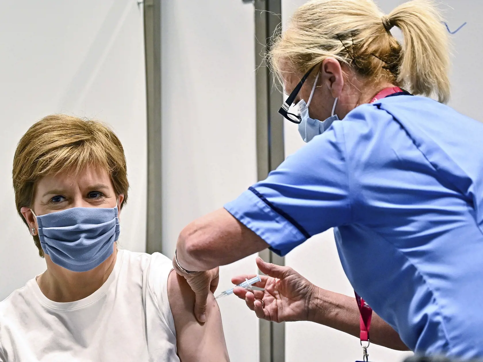 KK32 Glasgow - Škótska premiérka Nicola Sturgeonová dostáva druhú dávku vakcíny proti ochoreniu Covid-19 od spoločnosti AstraZeneca počas očkovania 21. júna 2021 v Glasgowe. FOTO TASR/Ap
First Minister of Scotland Nicola Sturgeon receives her second dose of the AstraZeneca Covid-19 vaccine, administered by staff nurse Susan Inglis, at the NHS Louisa Jordan vaccine centre in Glasgow, Scotland, Monday June 21, 2021. (Jeff J Mitchell/Pool via AP)