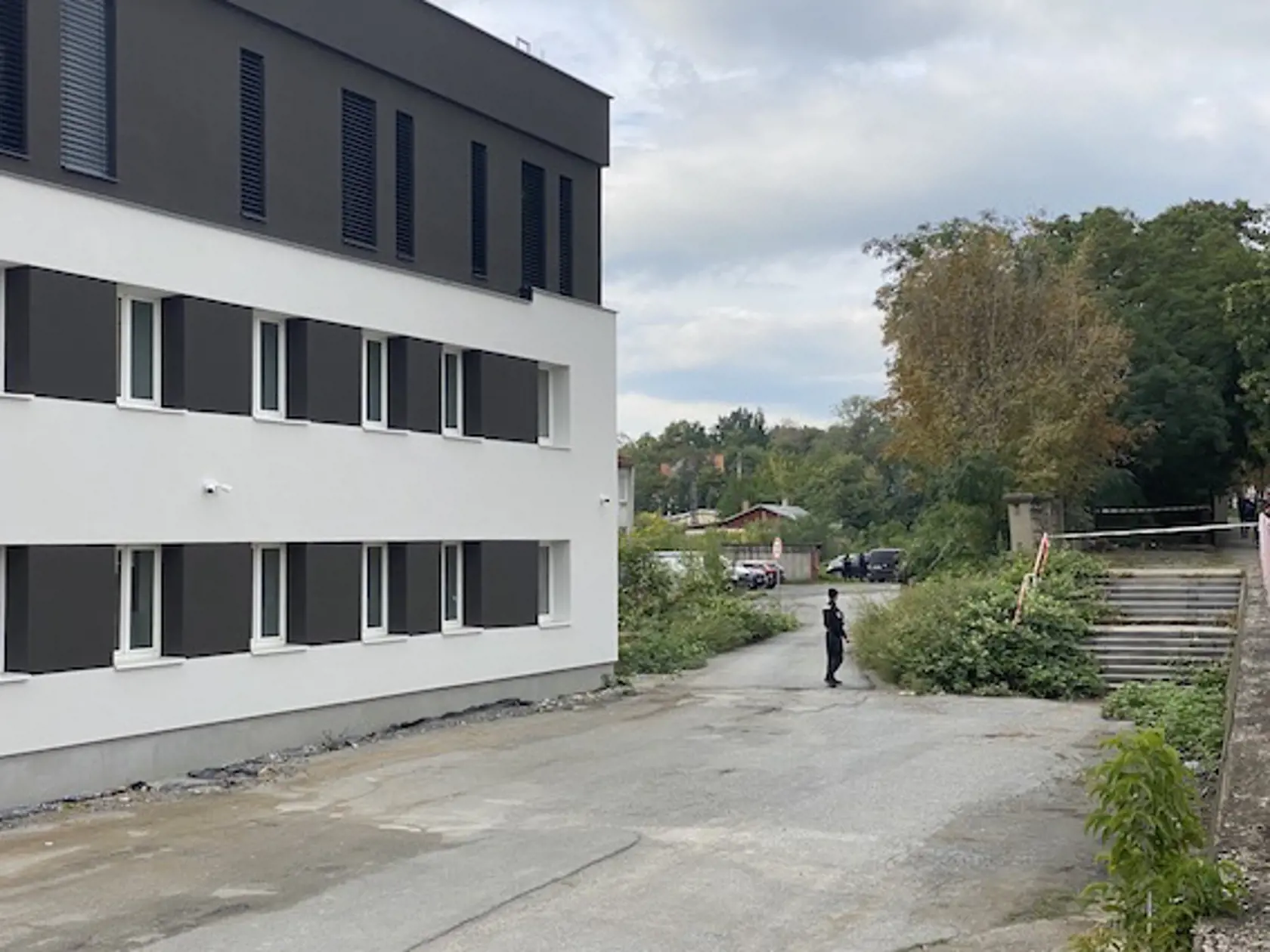 Medzi druhým a tretím oknom v smere od policajta na fotke ležalo telo nebohého Filipa (†29). Páchateľ ho zastrelil na parkovisku a on ešte prebehol pár metrov, kým nevládne spadol na zem.