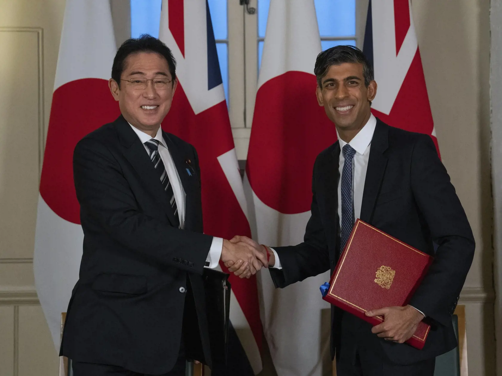 KK23 Londýn - Britský premiér Riši Sunak (vpravo) a  japonský premiér Fumio Kišida si podávajú ruky po podpísaní dohody o obrannej spolupráci počas bilaterálneho stretnutia 11. januára 2023 v Londýne. FOTO TASR/AP
Britain's Prime Minister Rishi Sunak, right, and Japan's Prime Minister Fumio Kishida shake hands after signing a defense agreement during a bilateral meeting at the Tower of London, Wednesday, Jan. 11, 2023. The leaders of Britain and Japan are signing a defense agreement on Wednesday