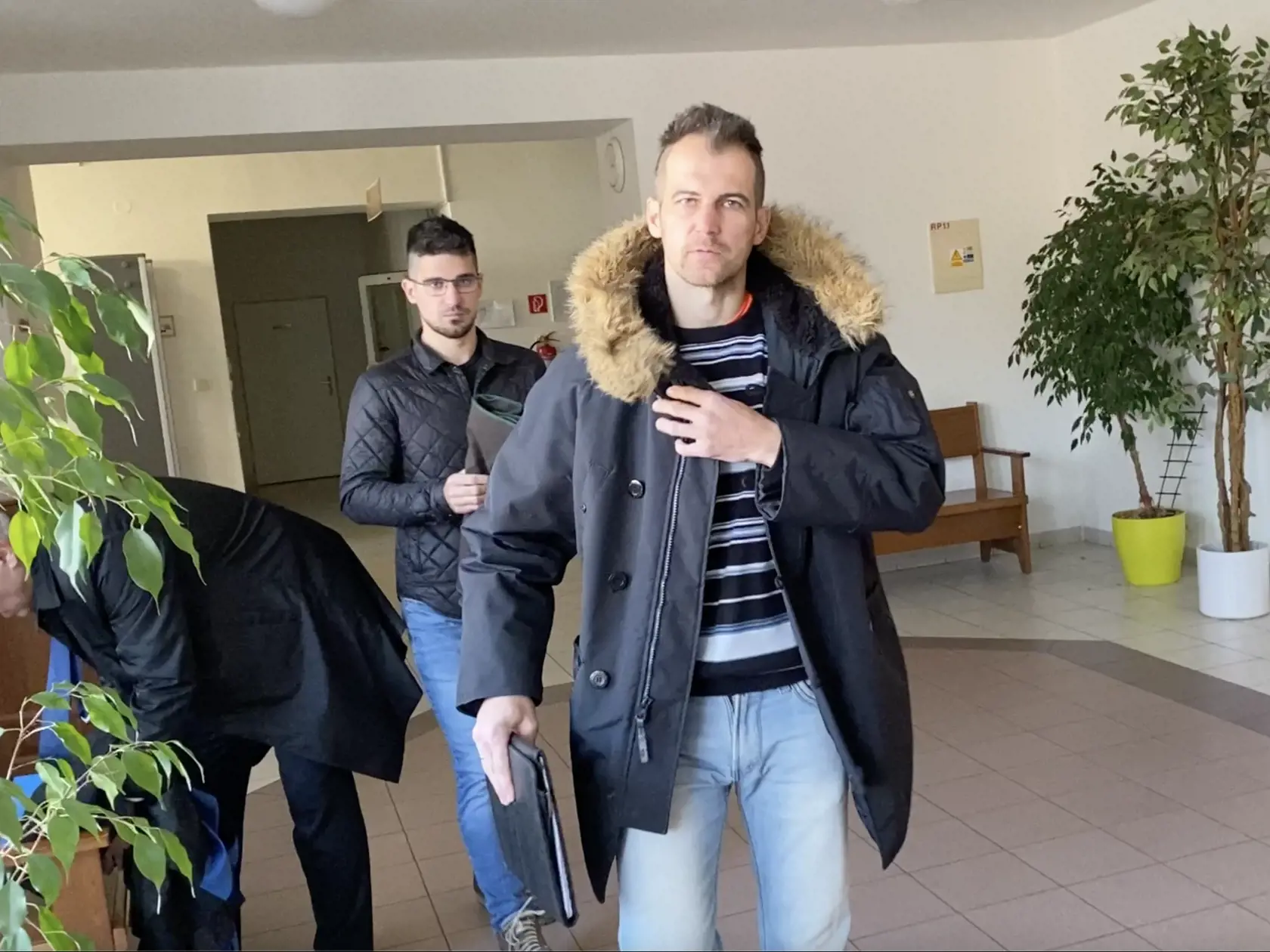 Pred začiatkom pojednávania. Marek (vpredu) a Rafael Kuffovci sa domáhali na chode súdu, vo verejnej budove, aby neboli snímaní.