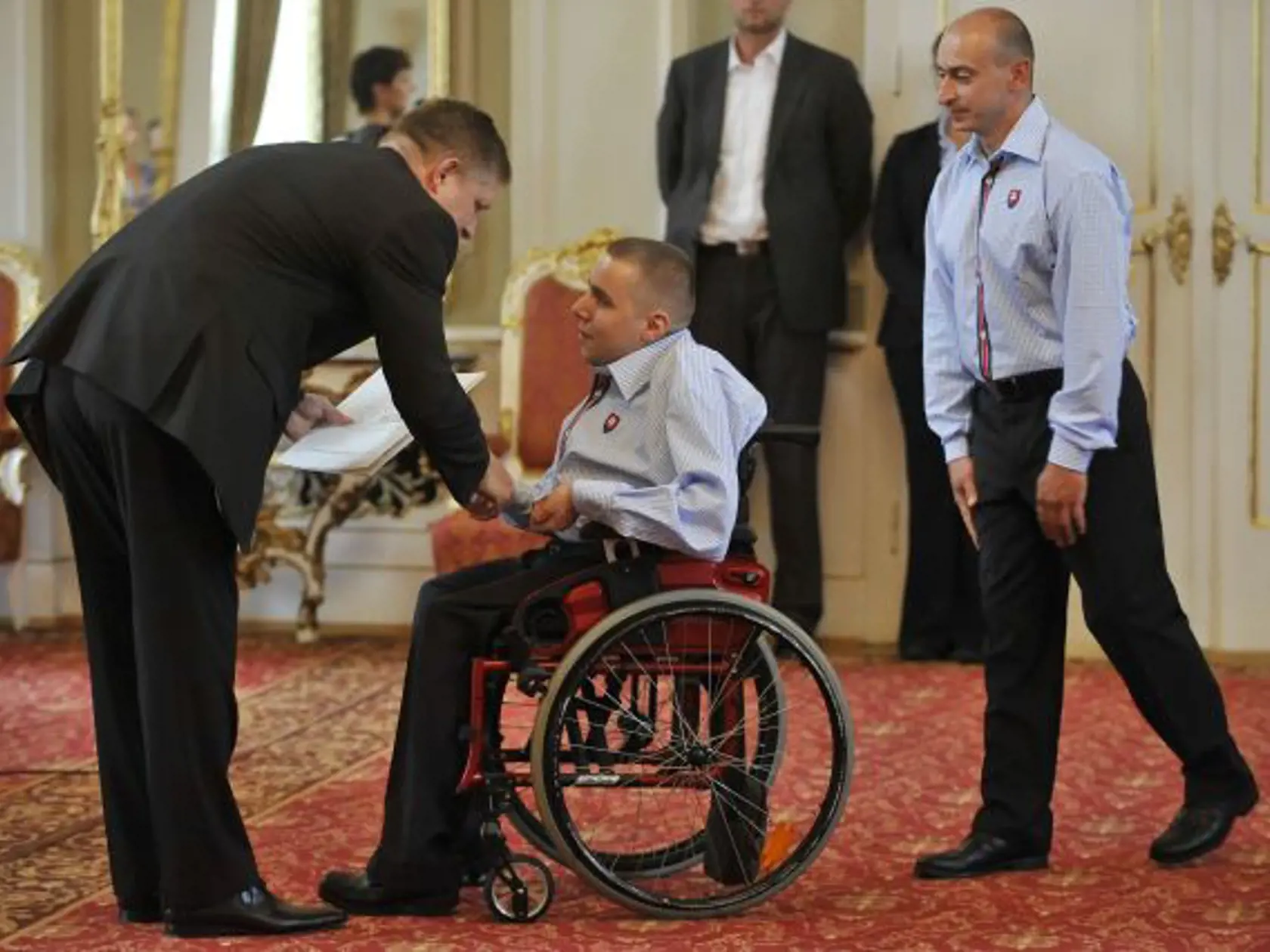 Predseda vlády SR Robert Fico prijal 21. augusta 2012 na Úrade vlády SR výpravu športovcov  - paralympionikov, ktorí budú reprezentovať Slovensko na paralympiáde v Londýne. Na snímke vľavo predseda vlády SR Robert Fico odovzdáva dekrét Róbertovi Ďurkovičovi (uprostred-BOCCIA).FOTO TASR - Pavel Neubauer