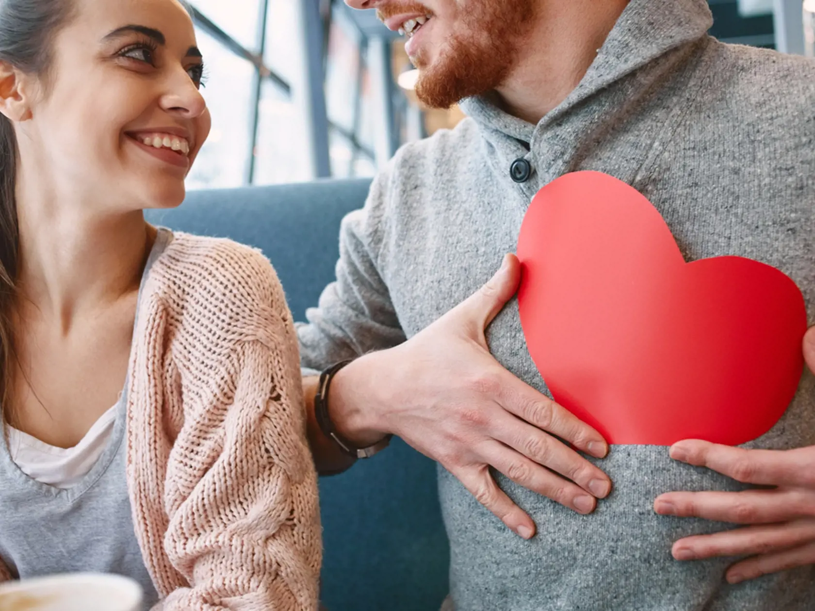 Man,And,Woman,Smiling,And,Holding,A,Large,Paper,Heart