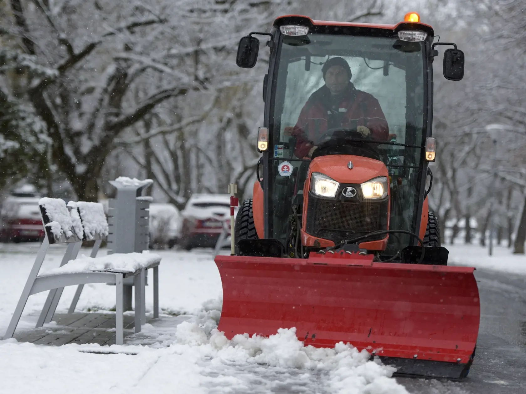Na snímke traktor s pluhom odhŕňa sneh na chodníku v parku Ostredky počas sneženia 22. januára 2023 v Bratislave. FOTO TASR - Pavol Zachar