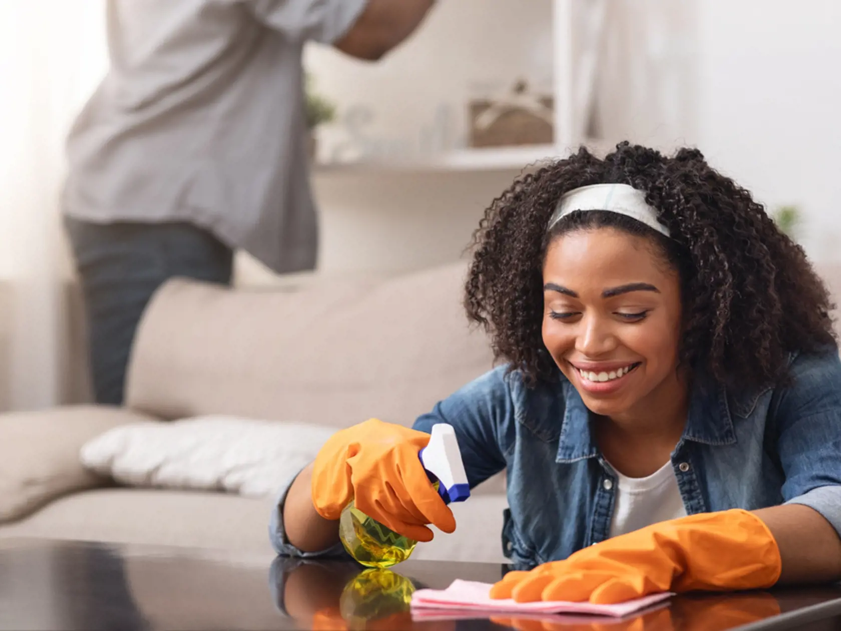 African,Couple,Making,Spring-cleaning,At,Home,Together,,Woman,Wiping,Table