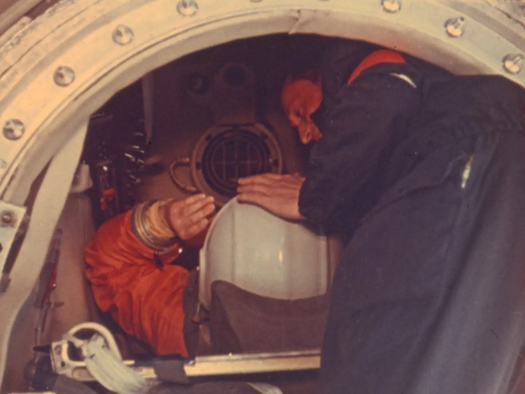 KK2 Bajkonur - Na archívnej snímke z 12. apríla 1961 konštruktér lode Vostok Oleg Ivanovskij (vpravo) nasadzuje prilbu Jurijovi Gagarinovi pred odletom do vesmíru v kozmickej lodi Vostok. Kozmonaut Sovietskeho zväzu (ZSSR) Jurij Gagarin pred 50 rokmi, 12. apríla 1961, v kozmickej lodi Vostok prvýkrát obletel Zem, èím otvoril bránu do vesmíru a epochu pilotovaných letov. FOTO TASR/AP  In this April 12 1961 photo, rocket engineer Oleg Ivanovsky pats Yuri Gagarin, left, on his helmet as he sits do