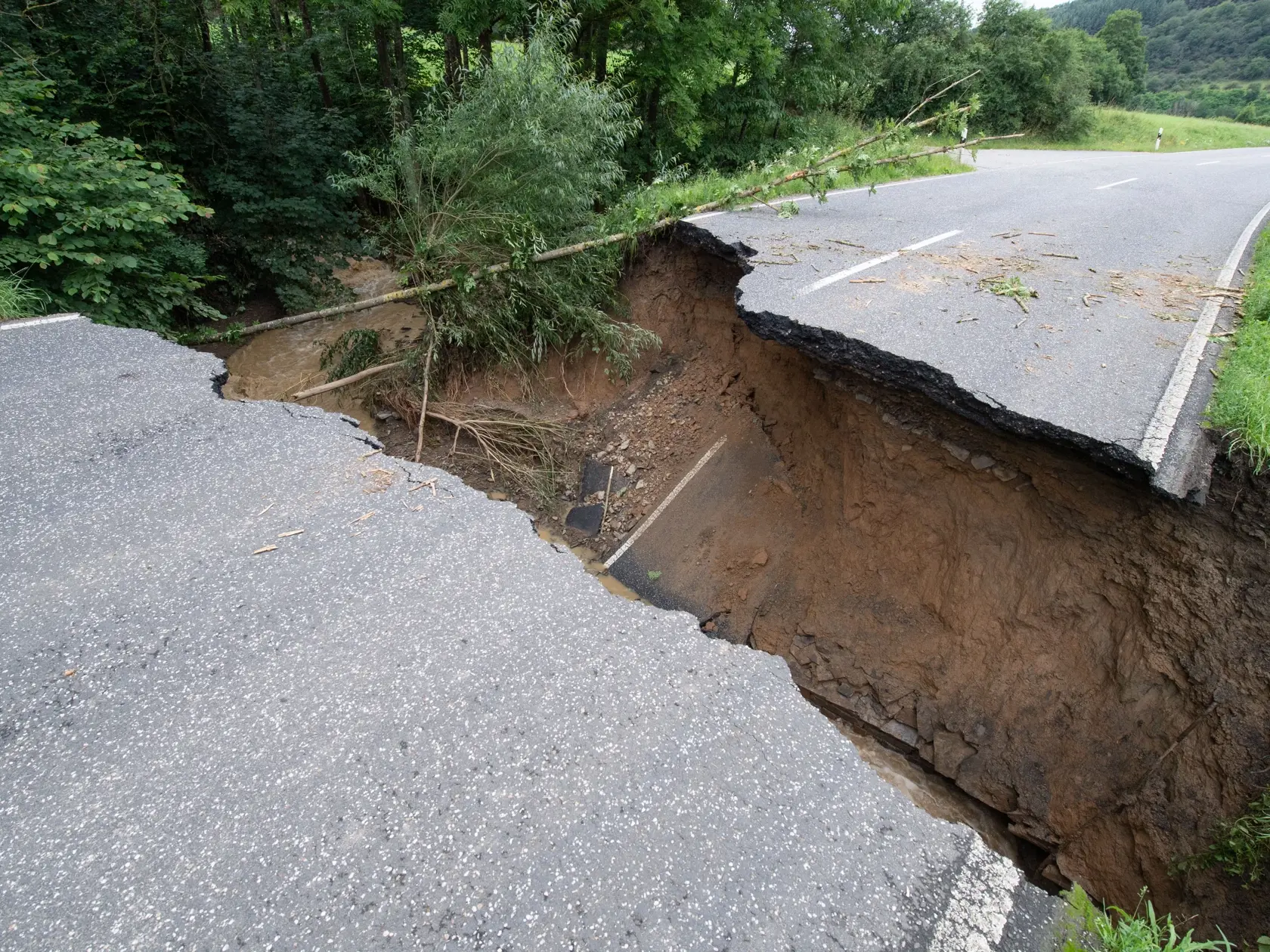 WA 32 Insul - Poškodená a prepadnutá cesta v obci Insul, nemeckej spolkovej krajine Porýnie-Falcko vo štvrtok 15. júla 2021. Najmenej 19 ľudí prišlo o život a približne 70 je nezvestných v dôsledku prudkých dažďov a záplav, ktoré v stredu zasiahli spolkové krajiny Severné Porýnie-Vestfálsko a Porýnie-Falcko. Nemecko do postihnutých oblastí vyslalo príslušníkov armády. Záplavy zasiahli aj ďalšie krajiny v západnej časti Európy, píše agentúra AP. FOTO TASR/DPA

15.07.2021, Rheinland-Pfalz, Insul: 