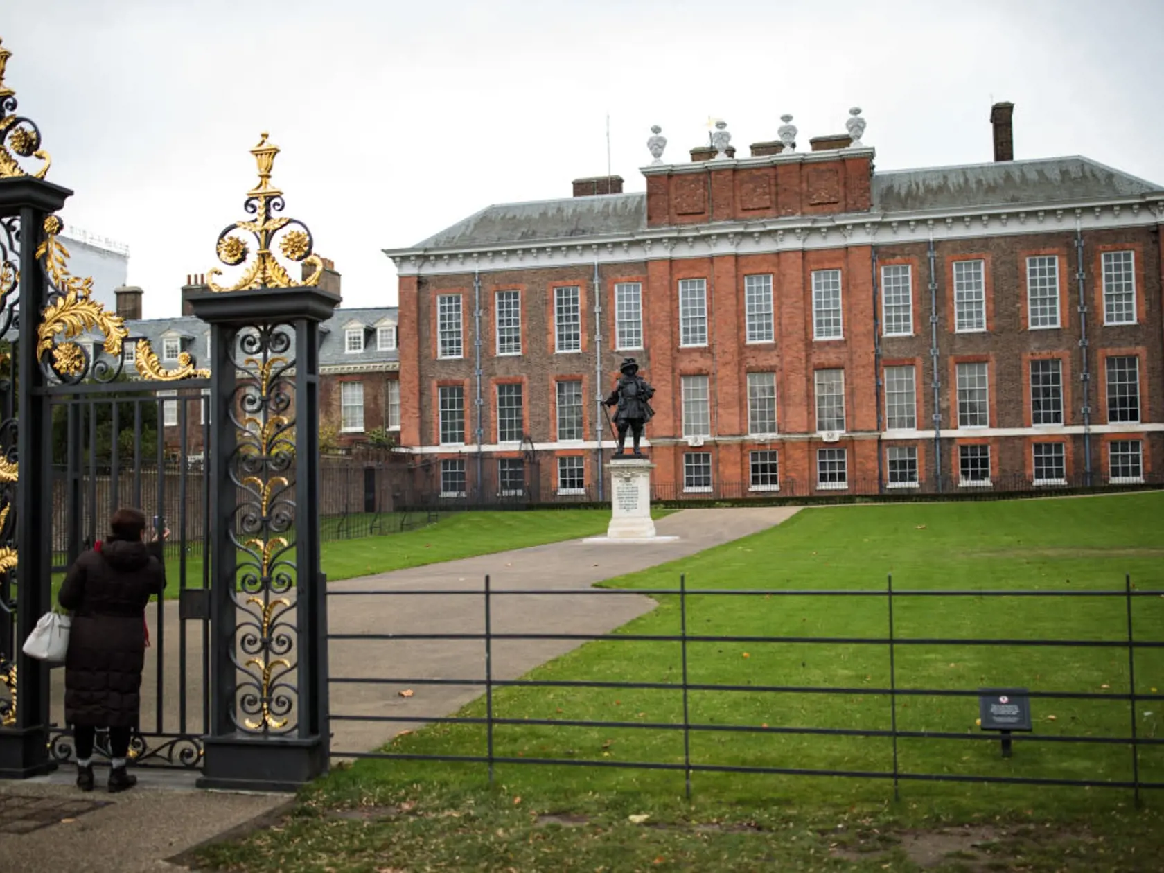 LONDON, ENGLAND - NOVEMBER 24: A woman takes a photo of Kensington Palace through the gates on November 24, 2017 in London, England. The American actress Meghan Markle will live at Nottingham Cottage in Kensington Palace as her engagement to Britain's Prince Harry was announced today. The pair have been a couple officially since November 2016 and are due to marry in Spring 2018. (Photo by Jack Taylor/Getty Images)