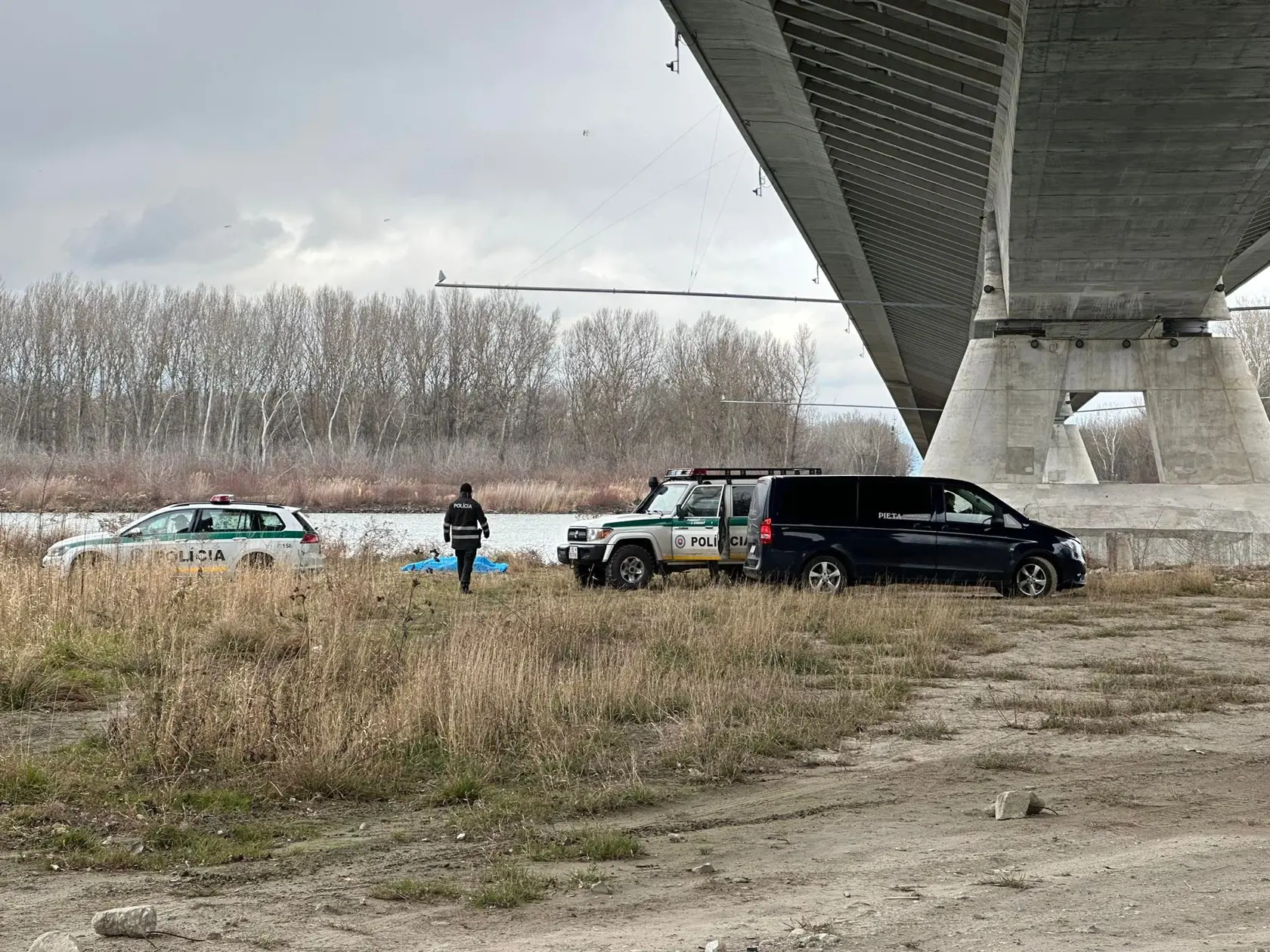 Telo nezvestnej 18-ročnej Terezky bolo nájdené pod mostom pri Dunaji ráno 1. februára 2023. Na snímke polícia a pohrebná služba.