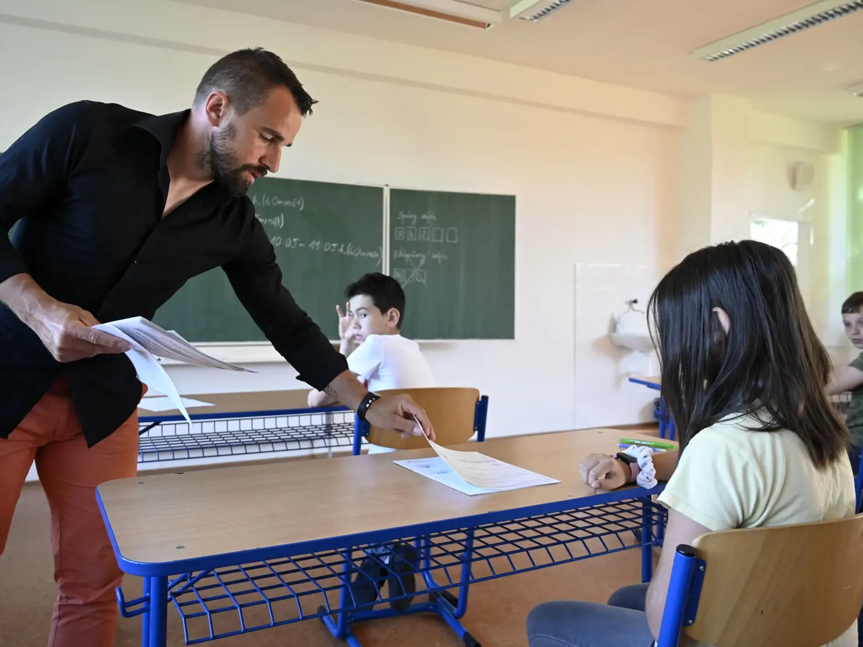 Na snímke učiteľ Jaroslav Capko rozdáva testy žiakom počas celoslovenského testovania žiakov 5. ročníka ZŠ na Cirkevnej základnej škole s materskou školou sv. Juraja v Trebišove v stredu 18. mája 2021. FOTO TASR - Roman Hanc