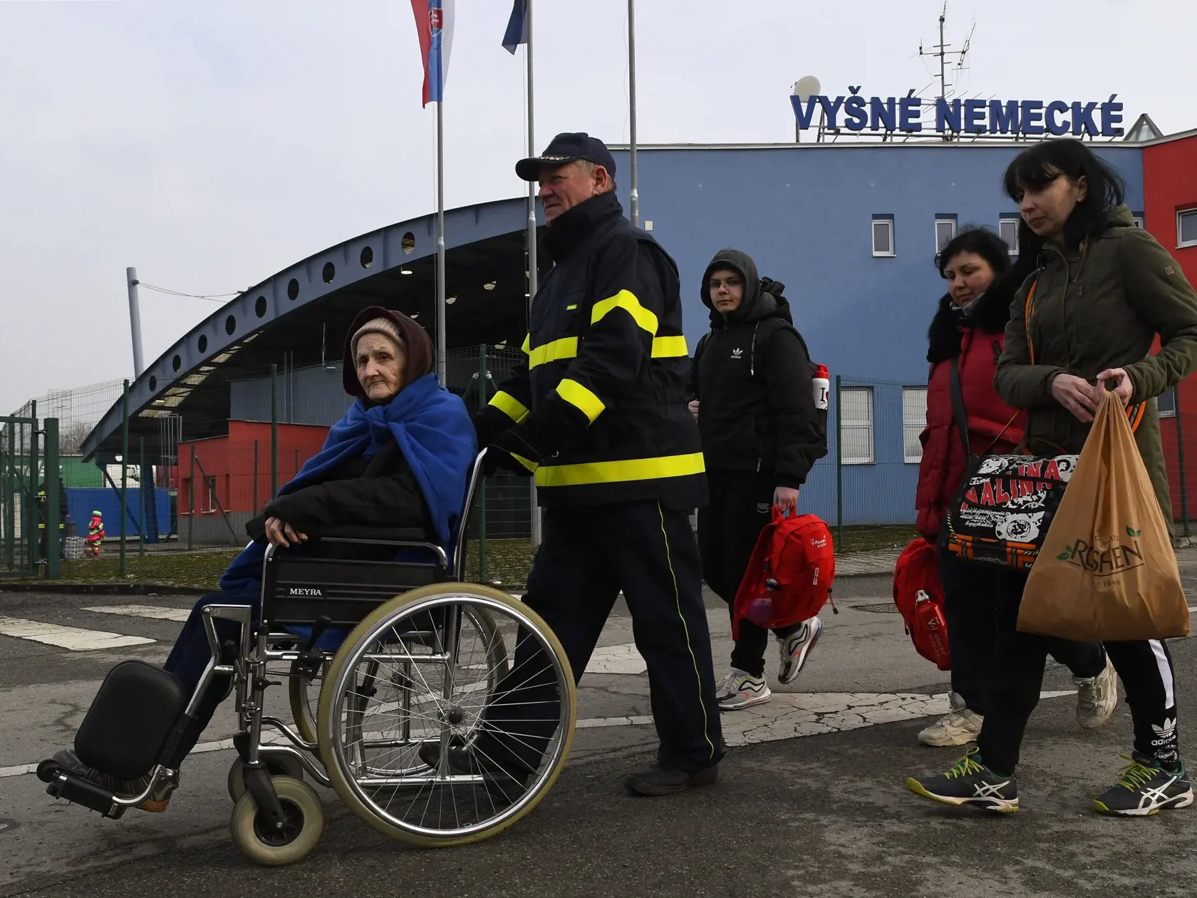 Snímka z príchodu ukrajinských utečencov na hraničnom priechode Vyšné Nemecké. Starým ľudom pomáhajú členovia Červeného kríža z Ukrajiny aj Slovenska. Vyšné Nemecké 16. marca 2022. FOTO TASR – Milan Kapusta
