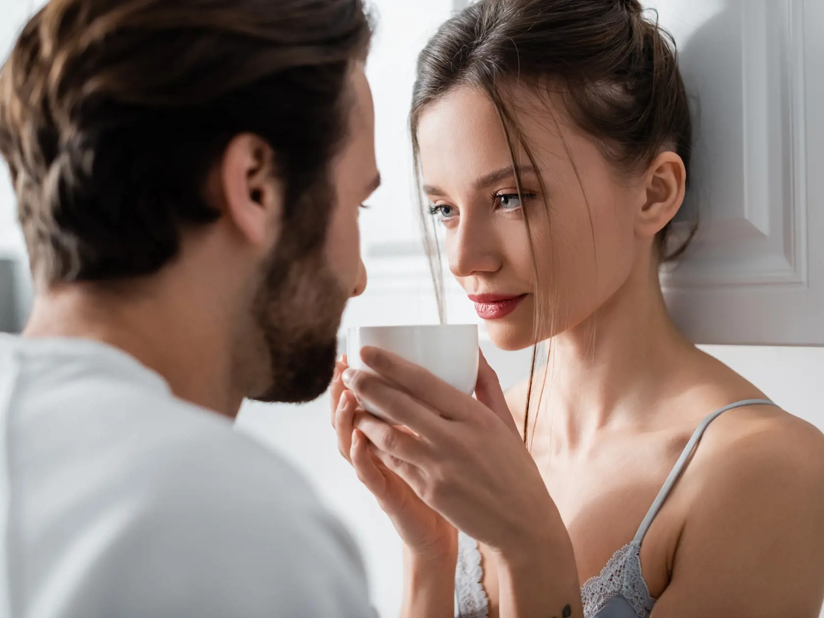 Young,Woman,In,Bra,Holding,Cup,And,Looking,At,Blurred