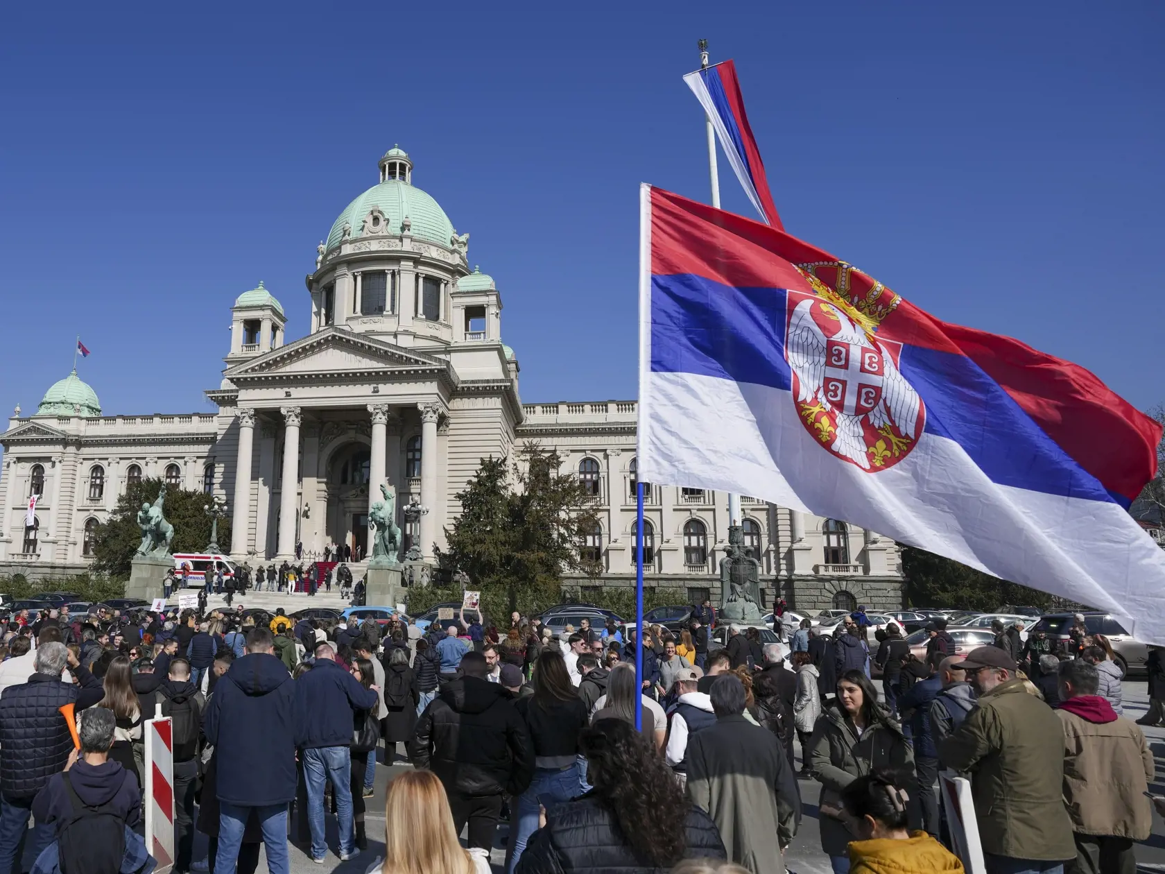 Ľudia si uctievajú 15 obetí minuloročného zrútenia strechy železničnej stanice v Novom Sade počas zasadnutia srbského parlamentu v Belehrade.