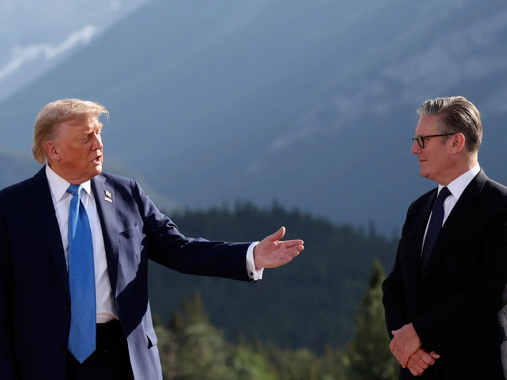 Na snímke prezident USA Donald Trump (vľavo) a britský premiér Keir Starmer diskutujú počas spoločného fotenia na jubilejnom 50. summite šéfov štátov a vlád skupiny G7 v Kananaskise 16. júna 2025.