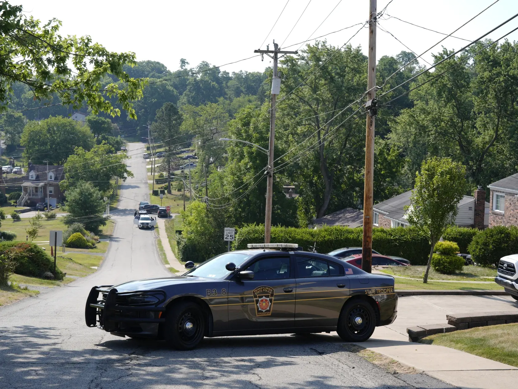 JB 77 Bethel Park - Policajti blokujú ulicu v meste Bethel Park 14. júla 2024 neďaleko domu strelca Thomasa Matthewa Crooksa, ktorý sa podľa amerických úradov pokúsil zabiť republikánskeho prezidentského kandidáta a exprezidenta Donalda Trumpa na jeho predvolebnom mítingu v nedeľu 13. júla v meste Butler v americkom štáte Pensylvánia. Vo vozidle a v dome muža, ktorý sa podľa amerických úradov posúdil zabiť exprezidenta Donalda Trumpa, našli výbušniny. S odvolaním sa na americké médiá a agentúry