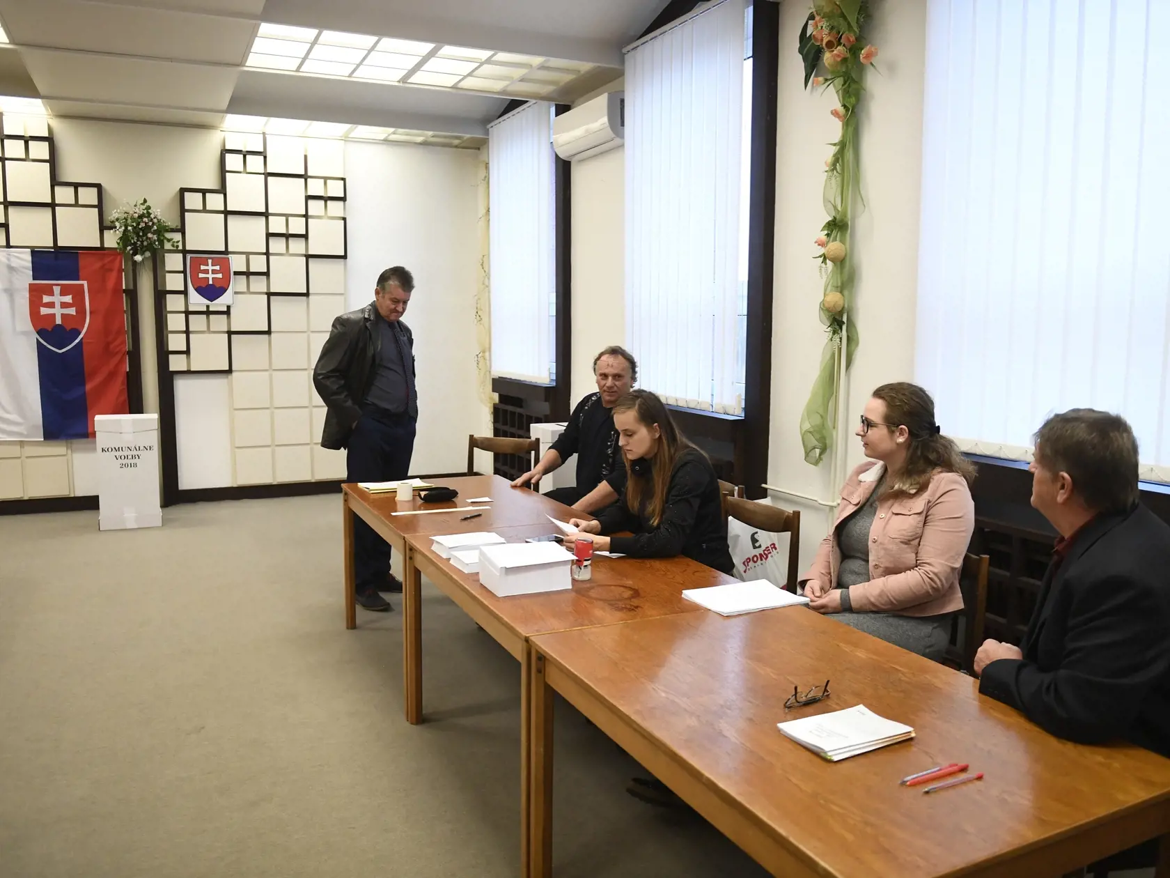 Prvá volička Trenčianskych Stankovciach prichádza krátko po siedmej hodine ráno vhodiť obálku s hlasovacími lístkami do volebnej schránky.