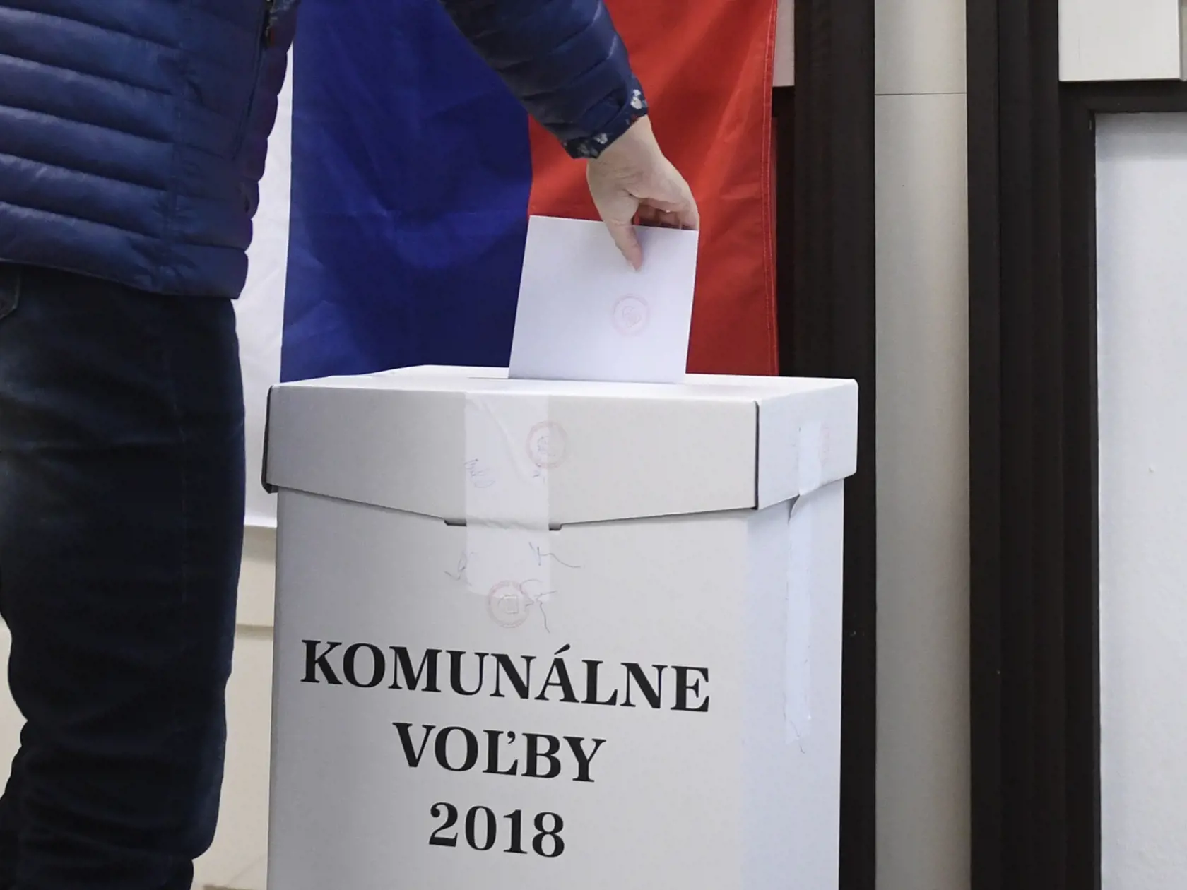 Prvá volička Trenčianskych Stankovciach prichádza krátko po siedmej hodine ráno vhodiť obálku s hlasovacími lístkami do volebnej schránky.