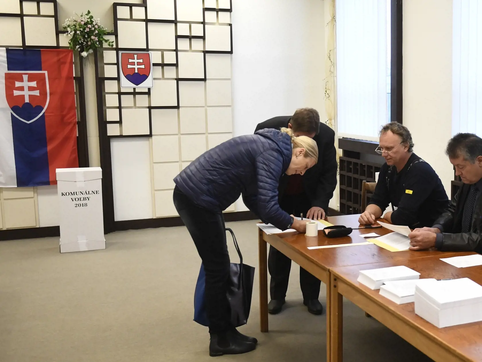 Prvá volička Trenčianskych Stankovciach prichádza krátko po siedmej hodine ráno vhodiť obálku s hlasovacími lístkami do volebnej schránky.
