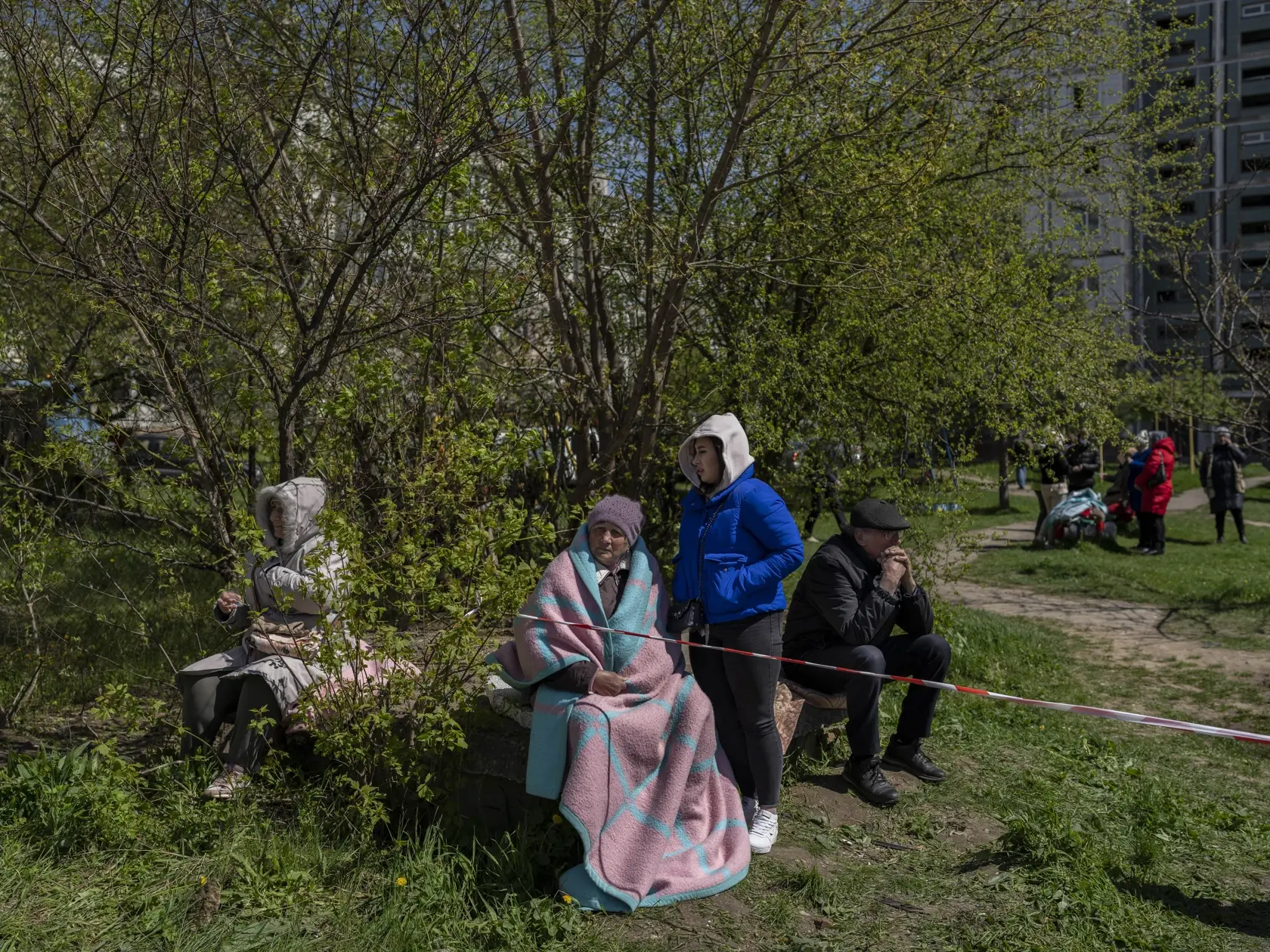 Na snímke obyvatelia sedia pred obytnou budovou po ruskom raketovom útoku na obytnú štvrť v ukrajinskom meste Umaň, vzdialeného 200 km južne od Kyjeva 28. apríla 2023.