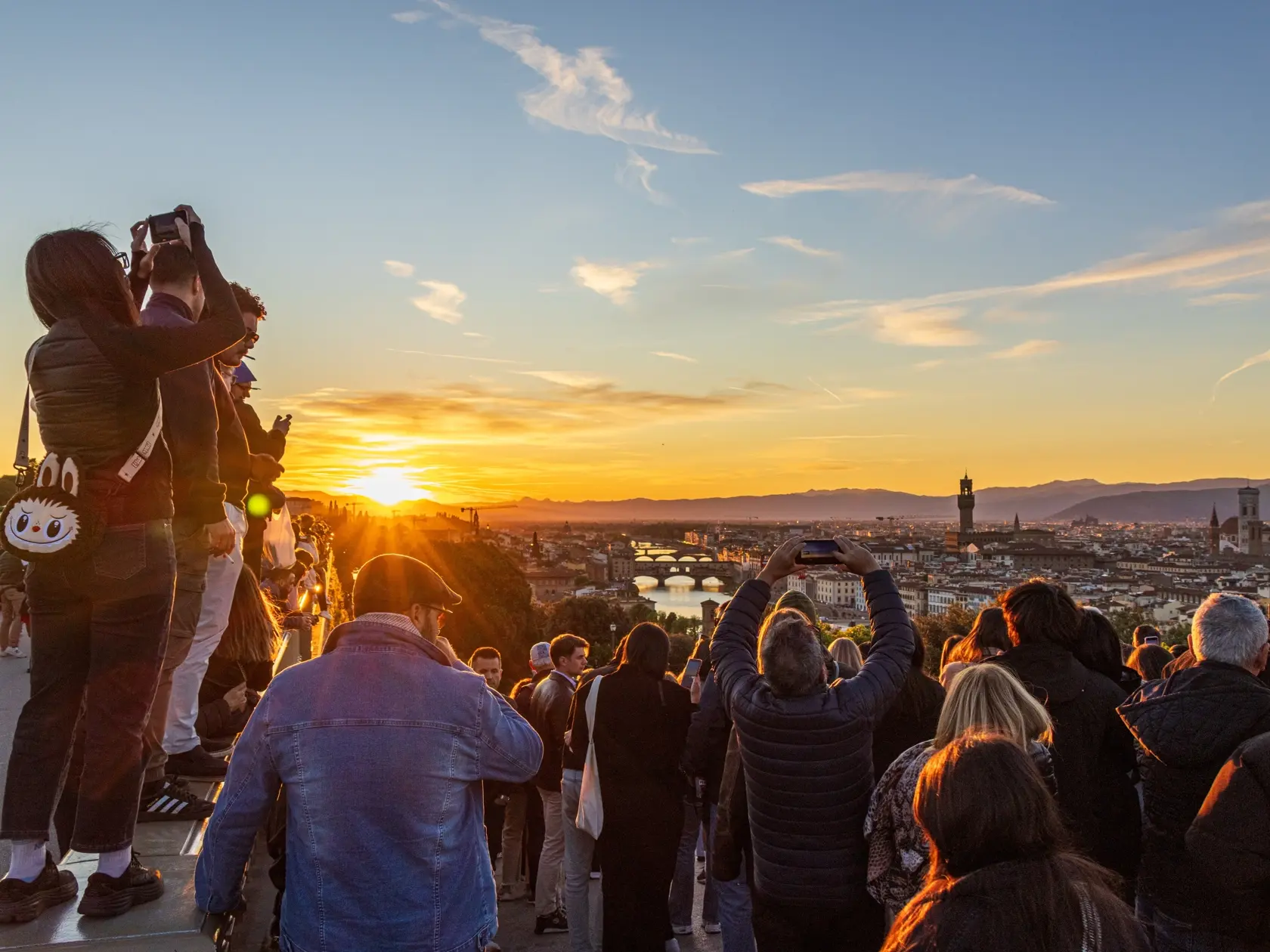 FLORENCE, ITALY - APRIL 20 2024. Crowds of tourists at Piazzale Michelangelo in Florence in Tuscany, Italy at sunset. People standing and stretching for a better view of the city.
