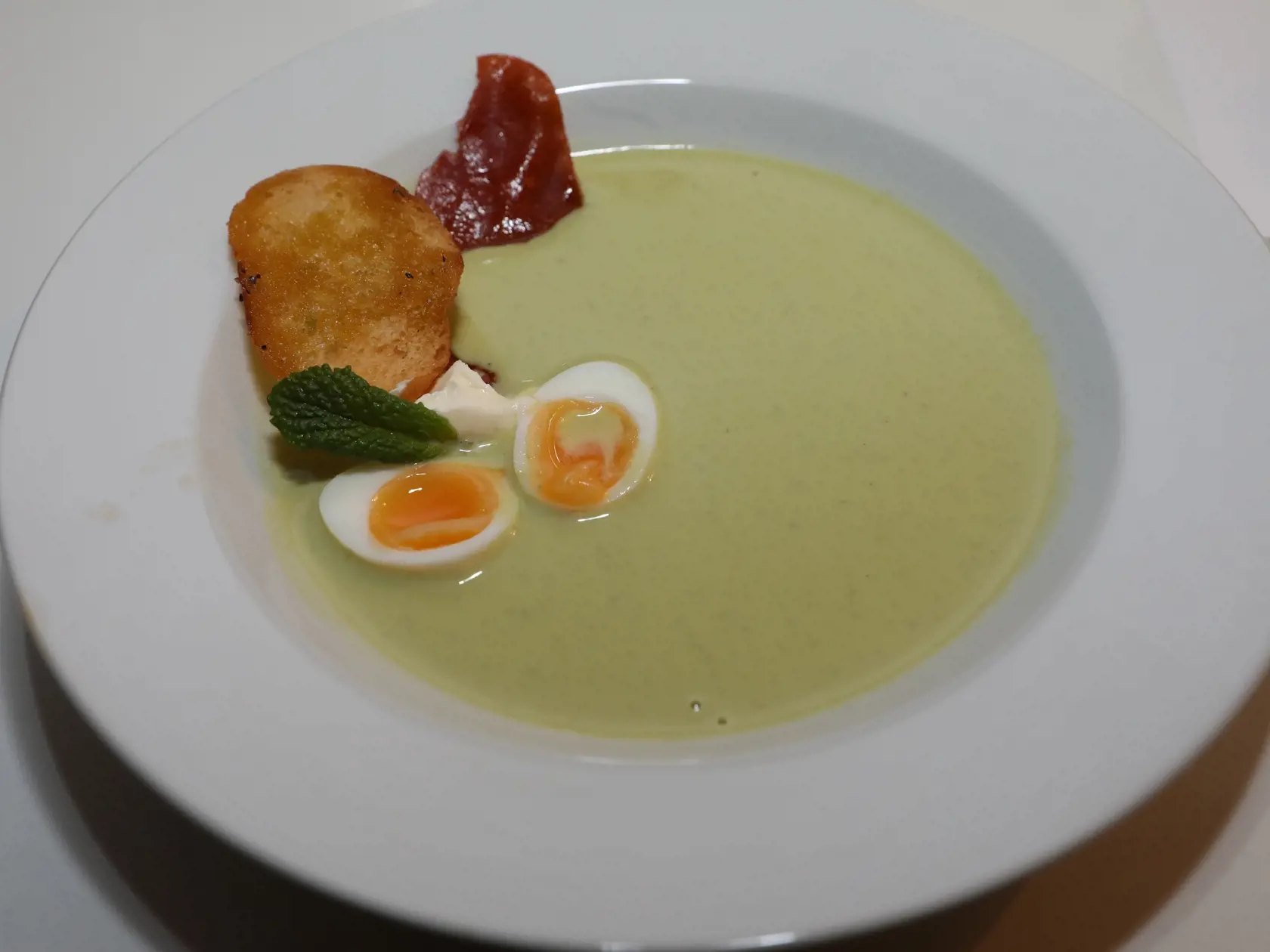 Súčasťou menu bol hráškový krém s mätou, prepeličím vajíčkom a slaninovým čipsom.
