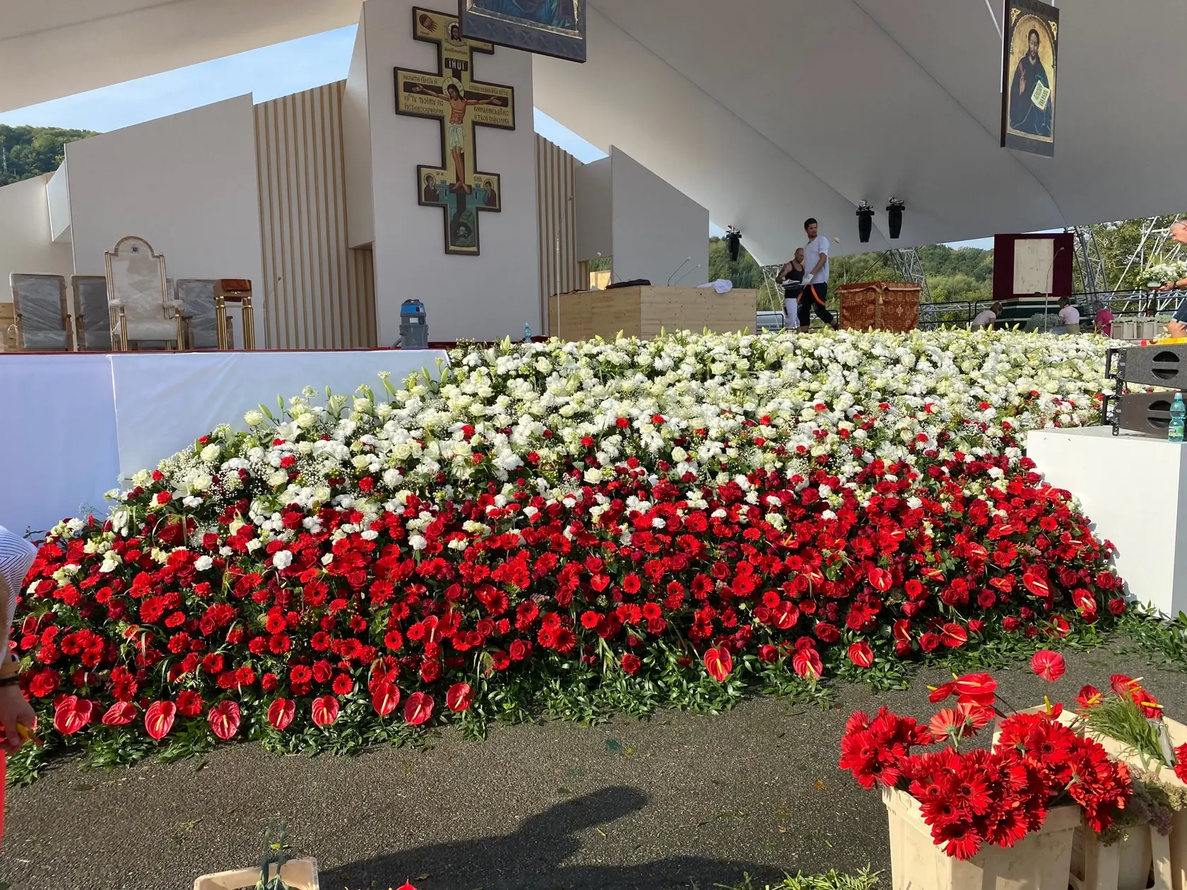 Prípravy liturgického priestoru - kvetinová výzdoba je ladená do bielej a červenej.