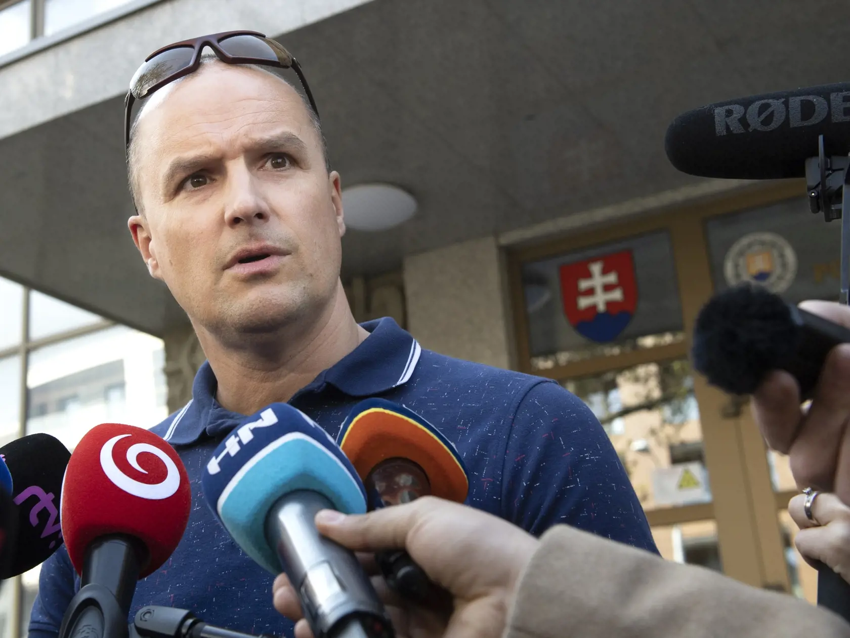 Obhajca Fica a Kaliňáka David Lindtner odpovedá na otázky novinárov počas výsluchu exministra vnútra Roberta Kaliňáka pred Prezídiom Policajného zboru SR v Bratislave v stredu 20. apríla  2022. Národná kriminálna agentúra (NAKA) obvinila expremiéra a šéfa Smeru-SD Roberta Fica i exministra vnútra Roberta Kaliňáka. Obvinenie dvojice a advokáta Mareka P. potvrdila aj polícia. FOTO TASR - Pavel Neubauer