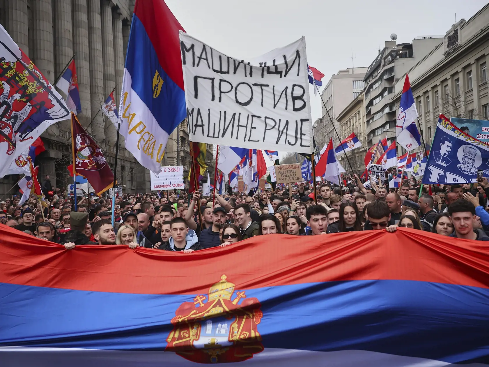 Demonštranti blokujú ulicu a mávajú srbskými zástavami počas veľkého protikorupčného zhromaždenia vedeného univerzitnými študentmi v Belehrade 15. marca 2025.