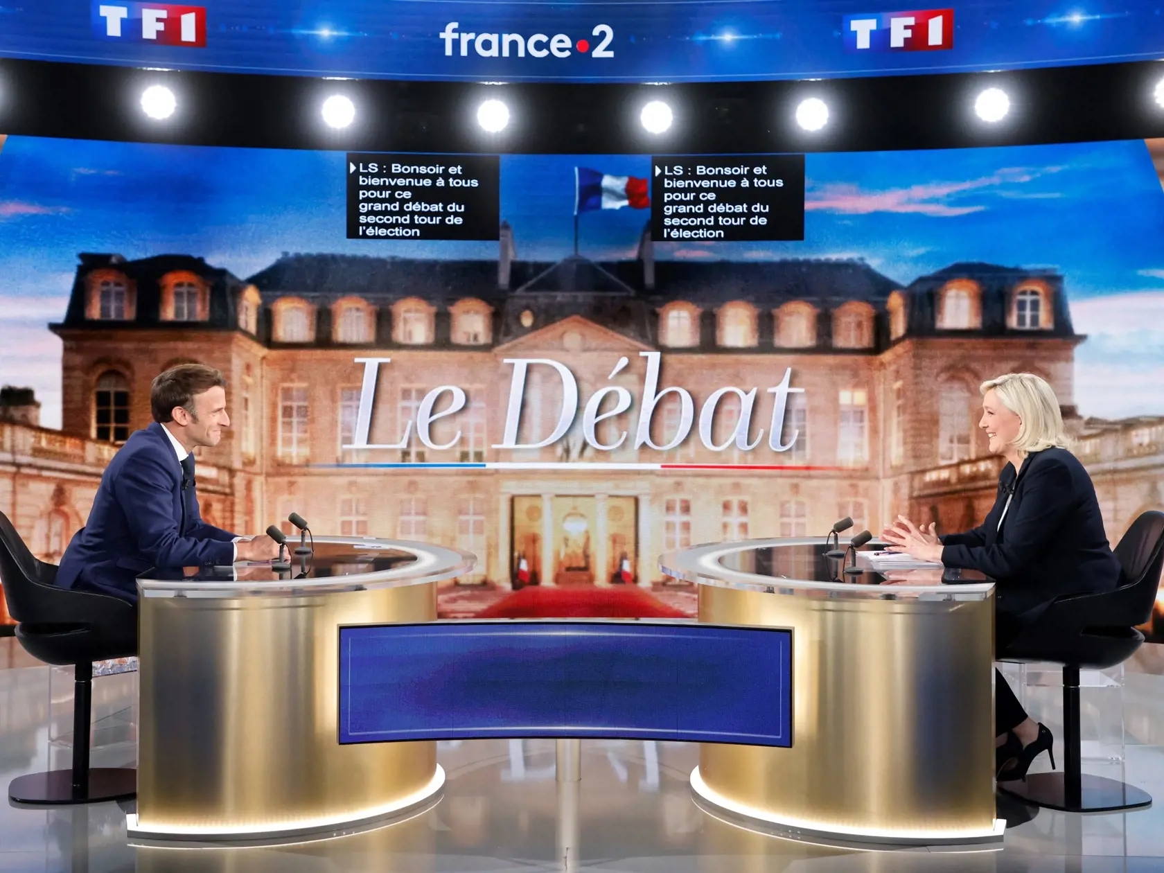 Francúzsky prezident a centristický prezidentský kandidát Emmanuel Macron (vľavo) a francúzska krajne pravicová líderka a prezidentská kandidátka Marine Le Penová sa usmievajú pred predvolebnou televíznou debatou v La Plaine-Saint-Denis pri Paríži 20. apríla 2022.