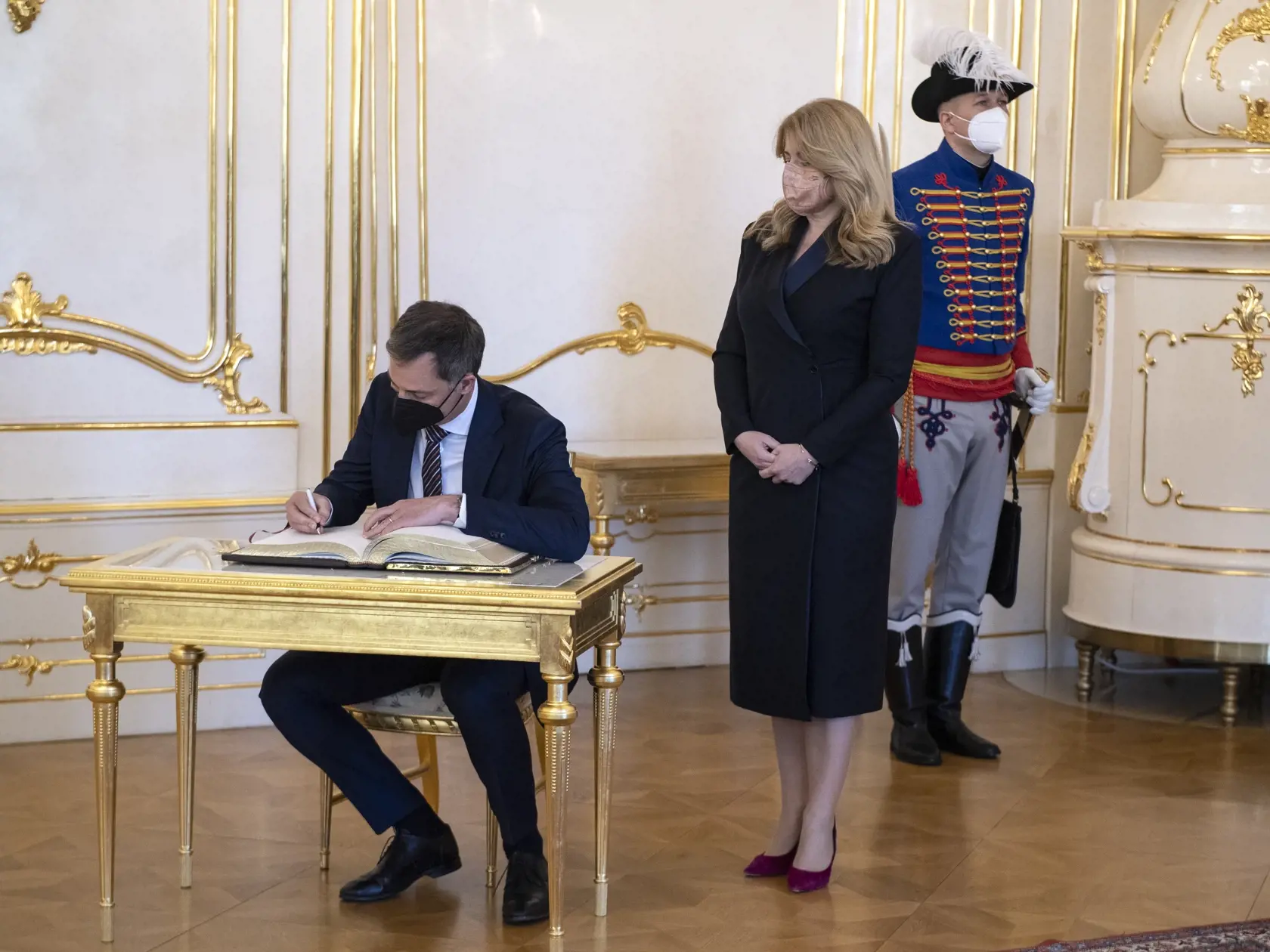 Na snímke vpravo prezidentka SR Zuzana Čaputová a vľavo predseda vlády Belgického kráľovstva Alexander De Croo sa zapisuje do čestnej knihy hostí počas stretnutia v Prezidentskom paláci 11. apríla 2022 v Bratislave. FOTO TASR - Pavel Neubauer

