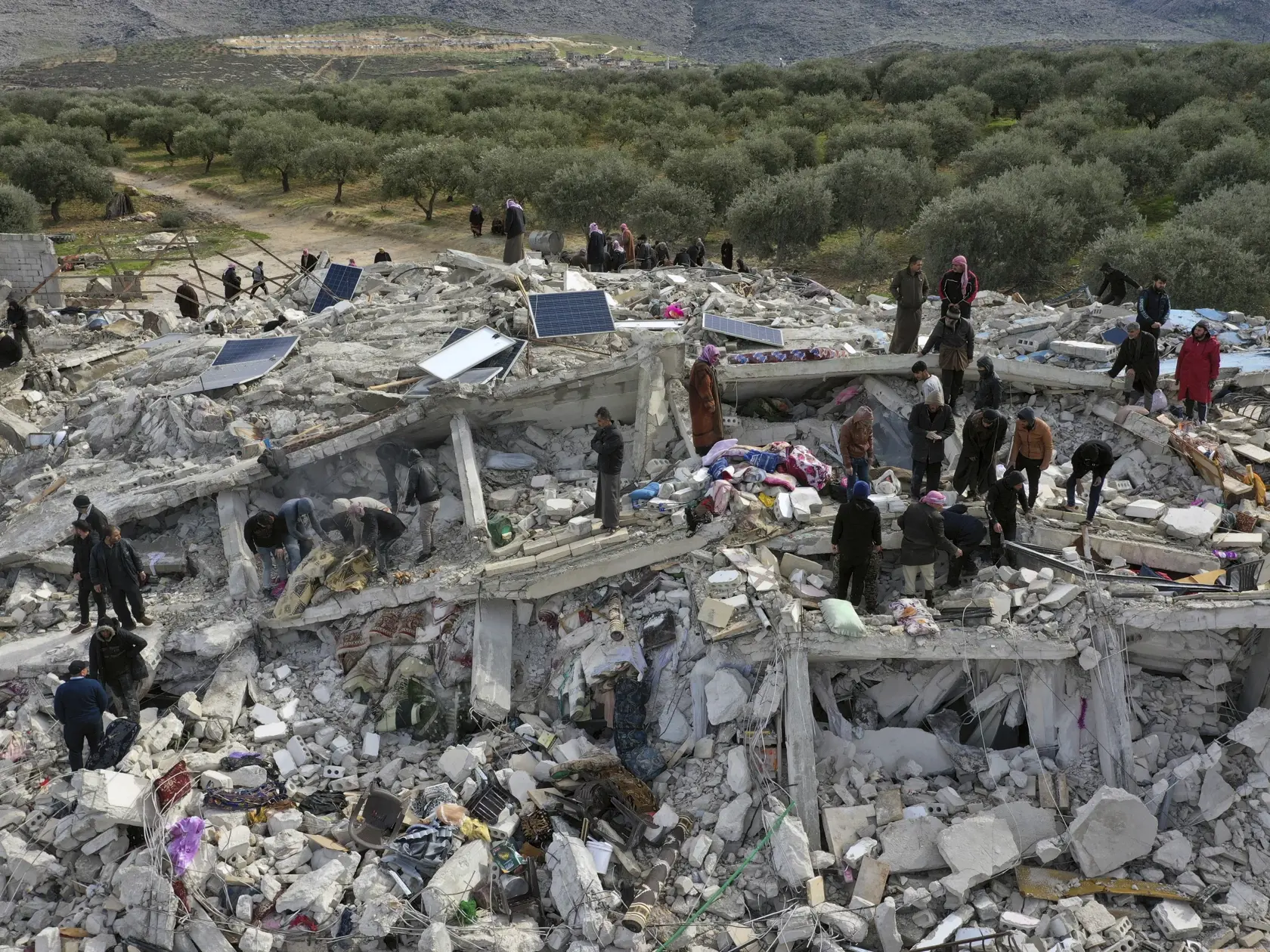KK3 Harem - Pracovníci civilnej obrany a obyvatelia prehľadávajú ruiny zrútených budov v meste Harem pri tureckých hraniciach v sýrskej provincii Idlib 6. februára 2023.