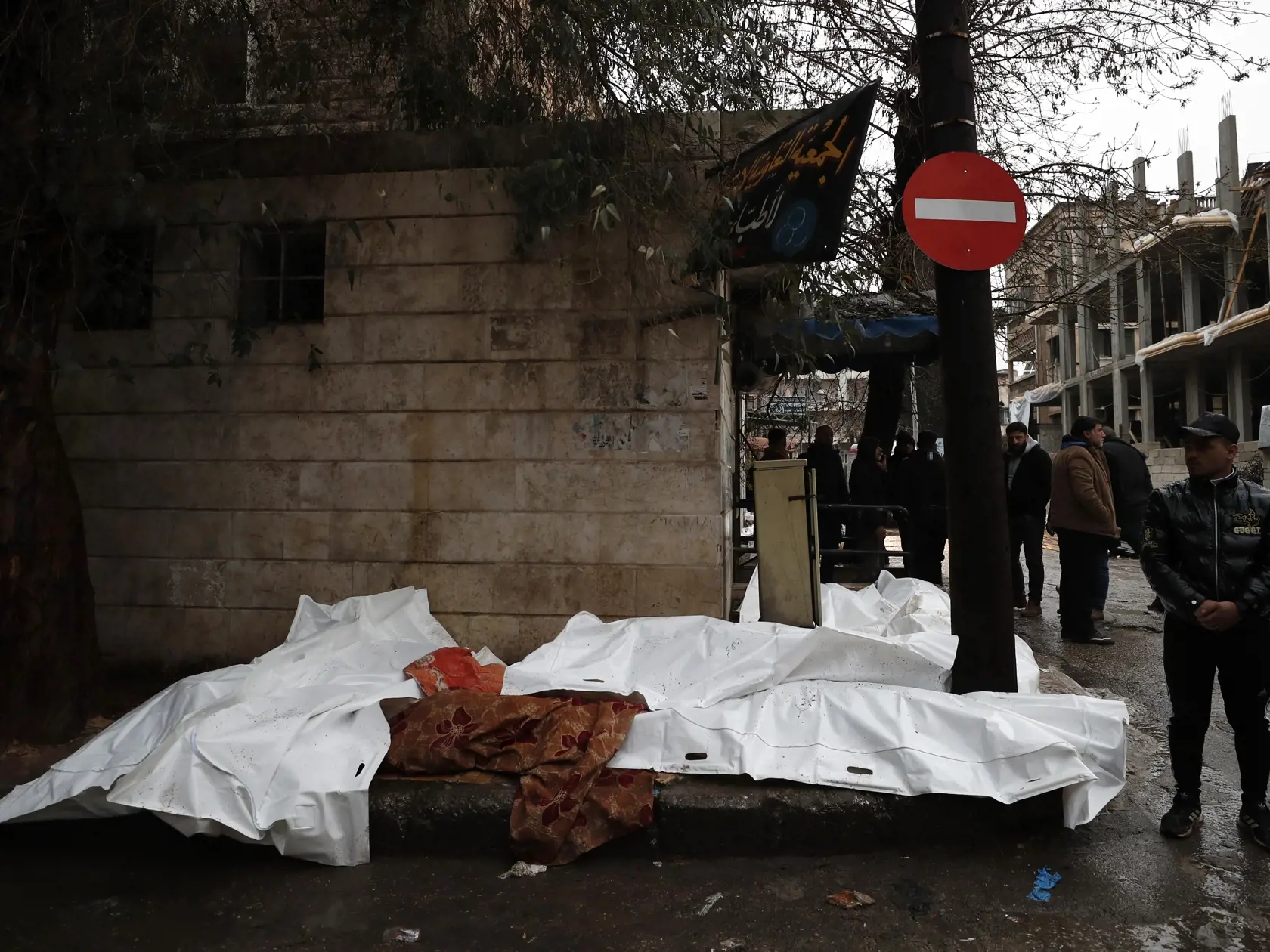 KK26 Aleppo - Ľudia sa snažia identifikovať telá obetí zemetrasenia, ktoré boli nájdené pred nemocnicou v sýrskom meste Aleppo 6. februára 2023.